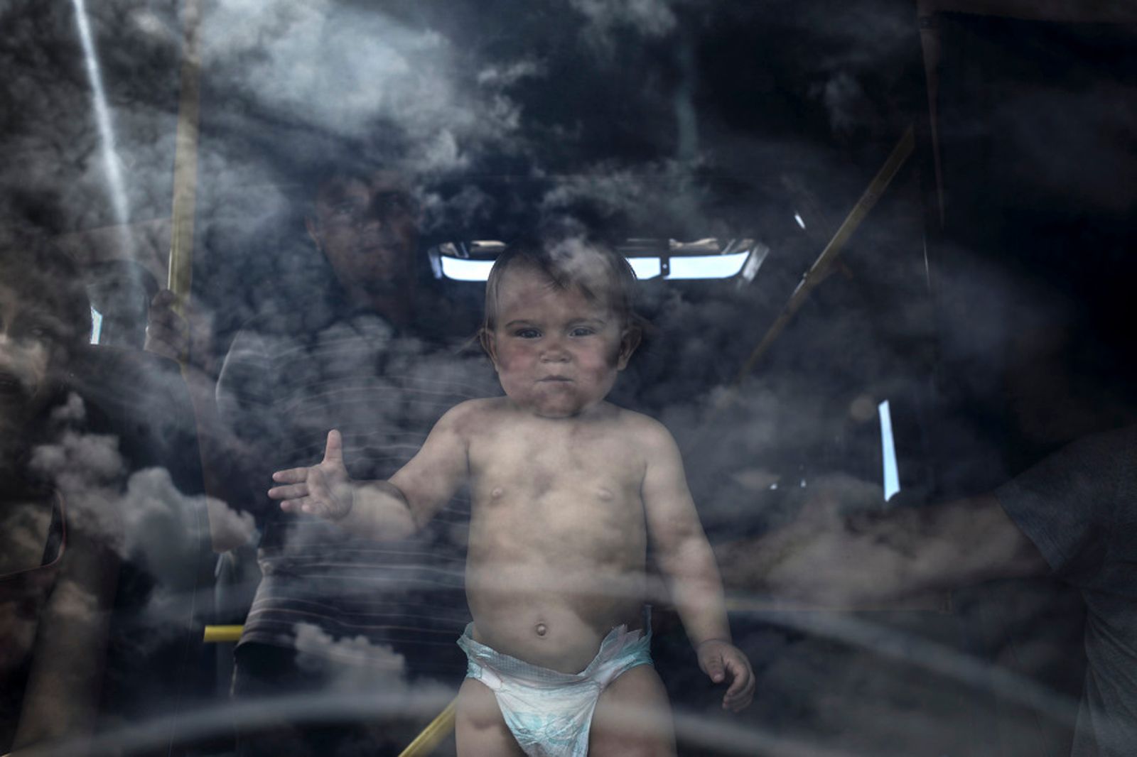 © Valery Melnikov - Refugee family and their child in the bus at the Izvarino border crossing point