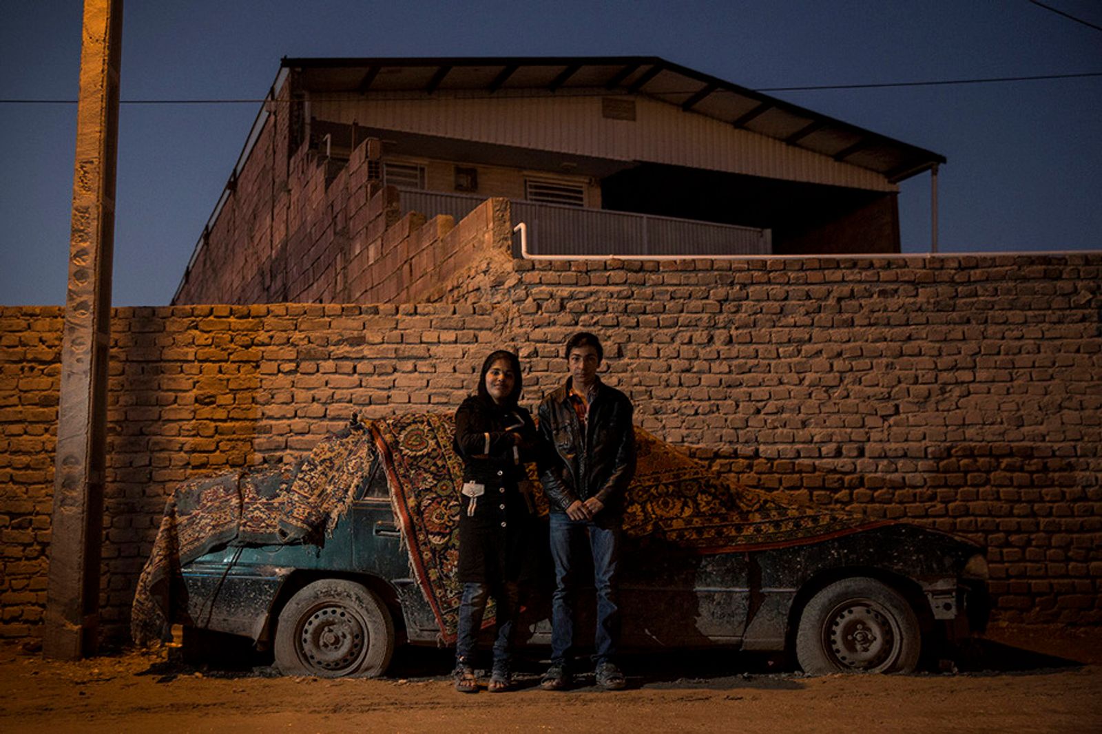 © Nazanin Tabatabaee Yazdi - Behzad and Zeinab are standing near their house.