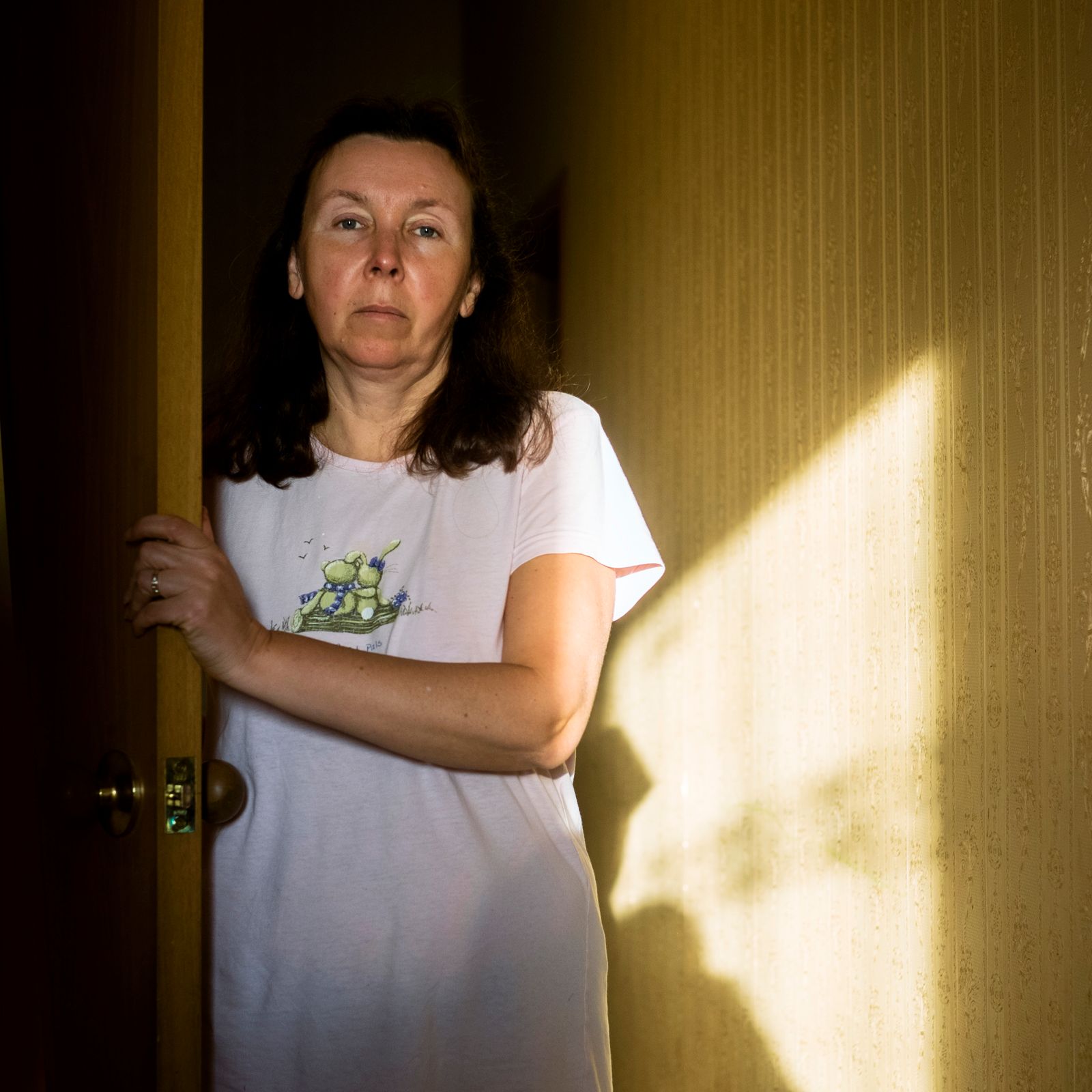 © Maria Quigley - Svetlana stands in the main corridor of the flat as the sun sets.