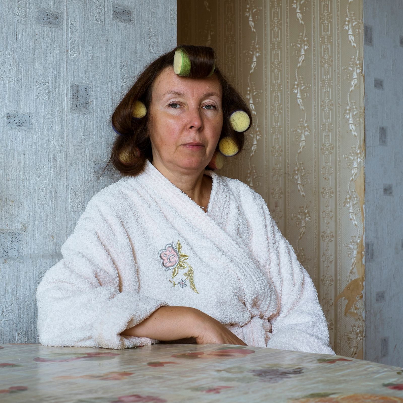© Maria Quigley - Svetlana, my mother, sits at the kitchen table. She is in the process of getting ready to attend Babushka's friends funeral.