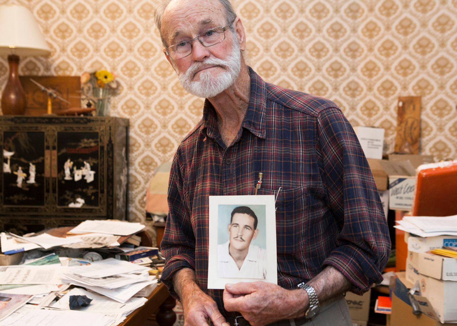 © Jessie Boylan - Avon Hudson holds a photograph of himself from 1954 at home in his archives room.