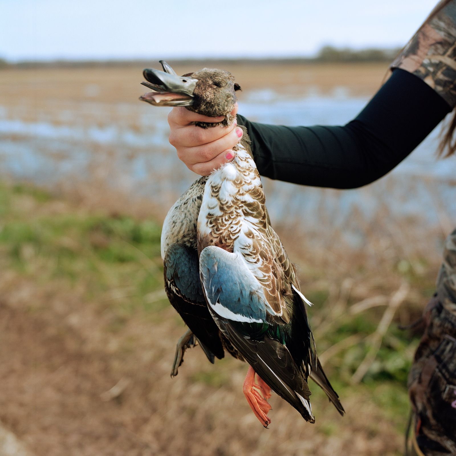 © Camille Farrah Lenain - Beth, 27, holding a dead duck she had harvested earlier than morning in Goldust, Louisiana. November 2019.