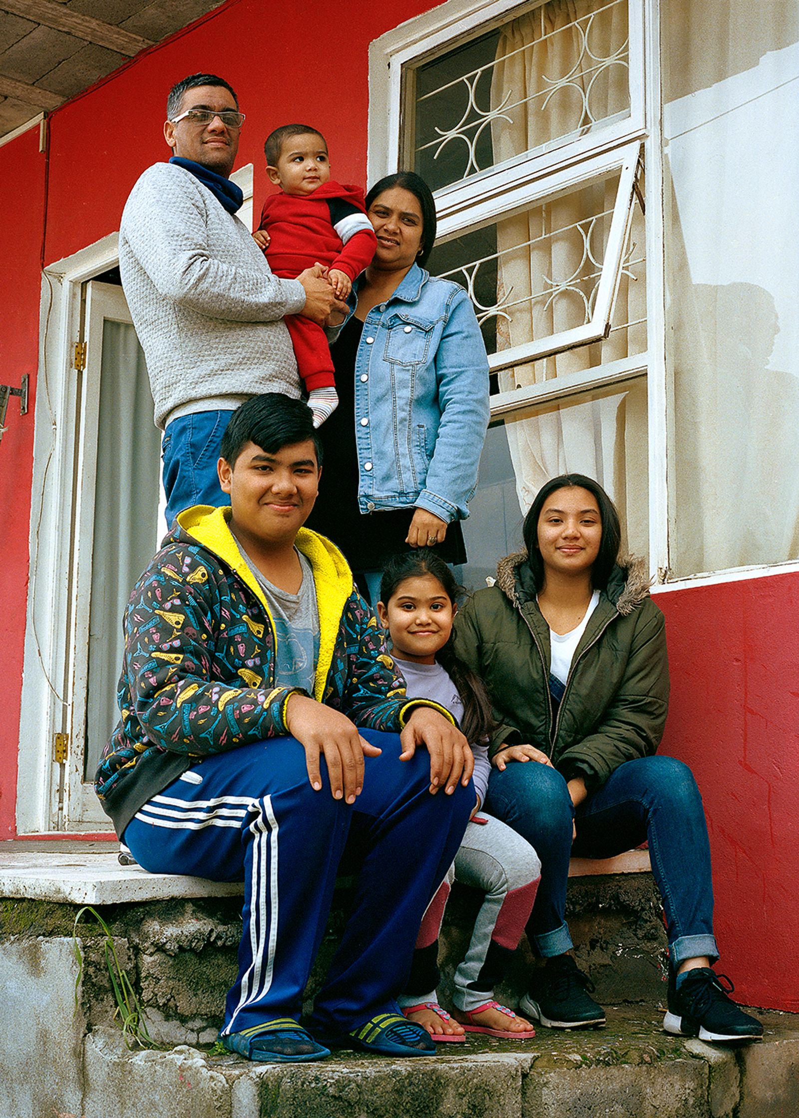 © Ayesha Kazim - Mahier and his family stand for a portrait outside of their home in Bo-Kaap.
