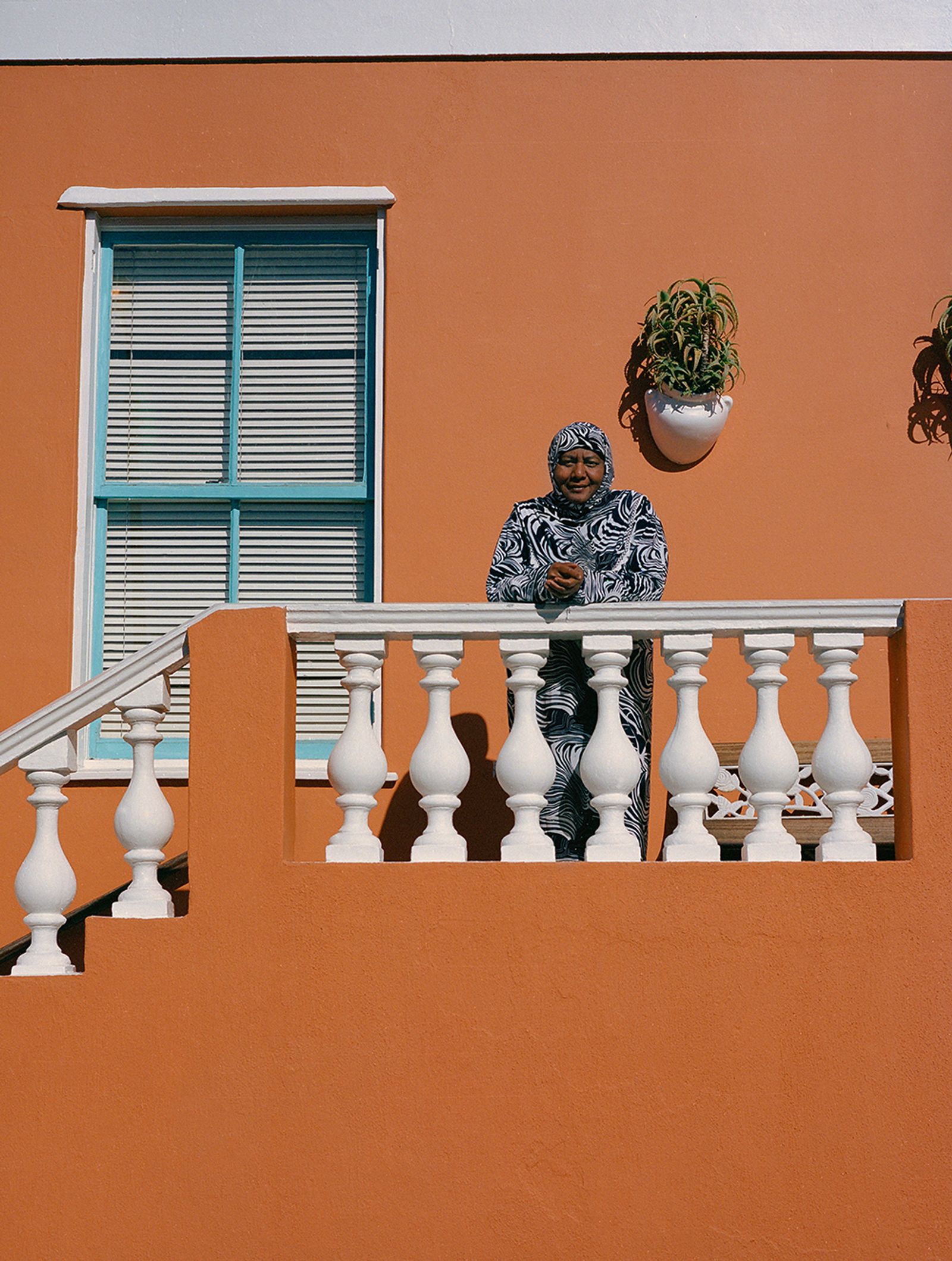 © Ayesha Kazim - Rashieda, a long-time resident of Bo-Kaap, stands for a portrait from her balcony on Wale Street.