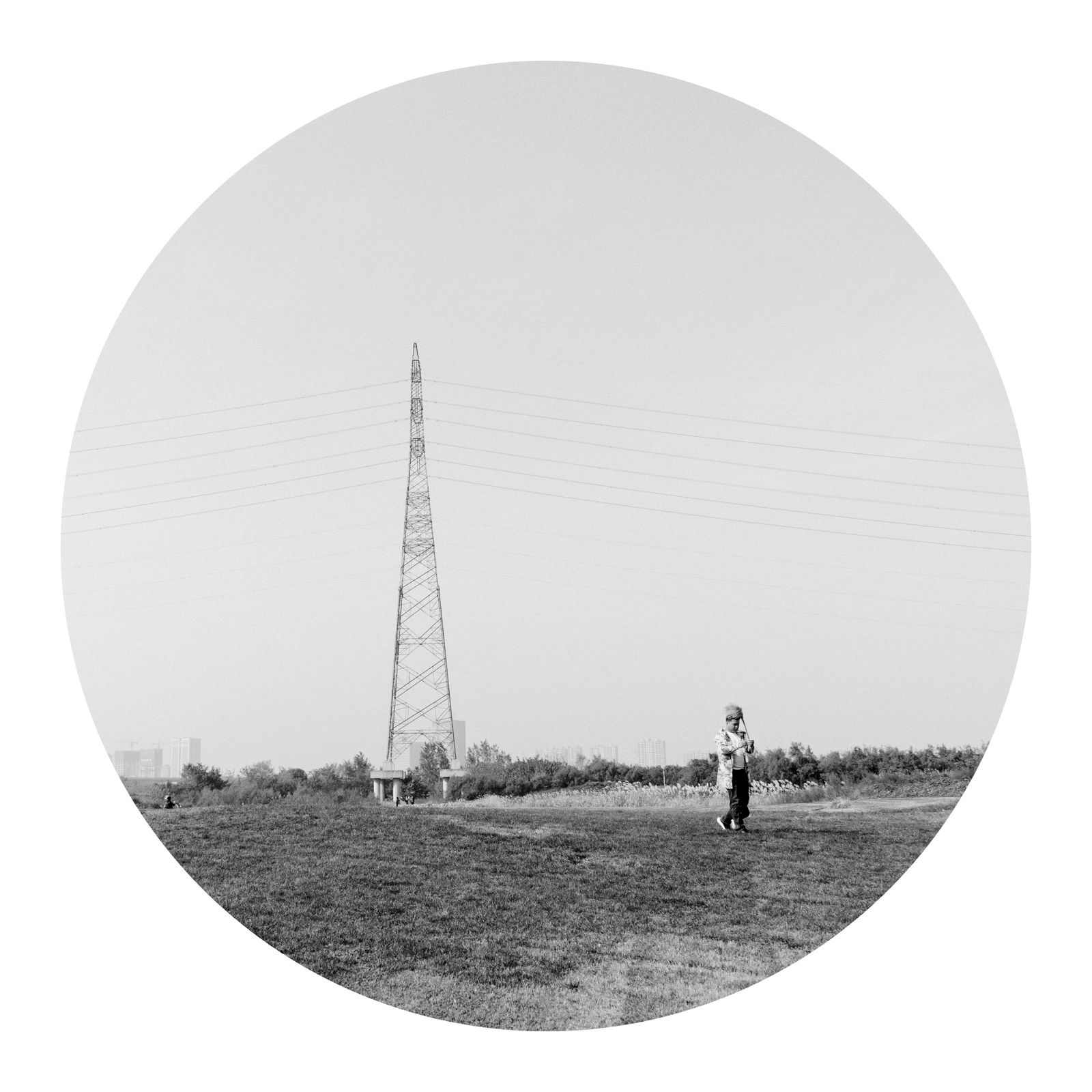 © Tianhu Yuan - A man picks up a bunch of reeds and walks through the riverside park.