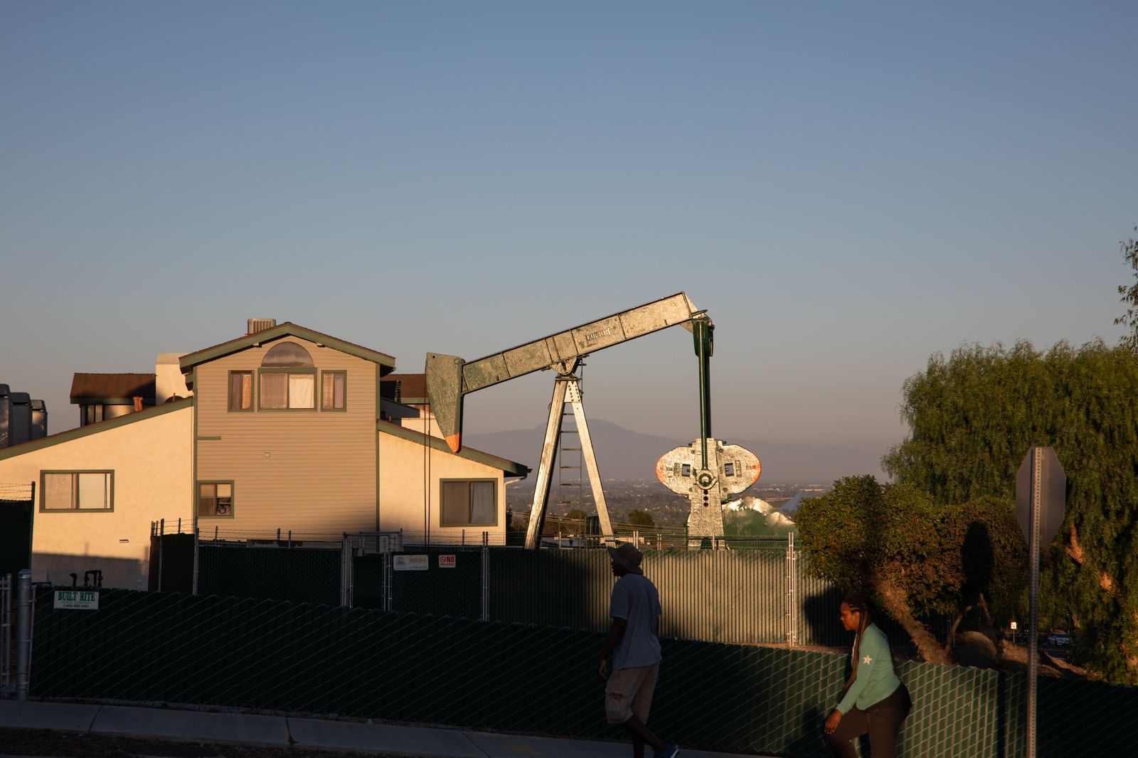 © Tara Pixley - Residents of Signal Hill, a Long Beach suburb, walk its streets in the shadow of dozens of pumping oil jacks.