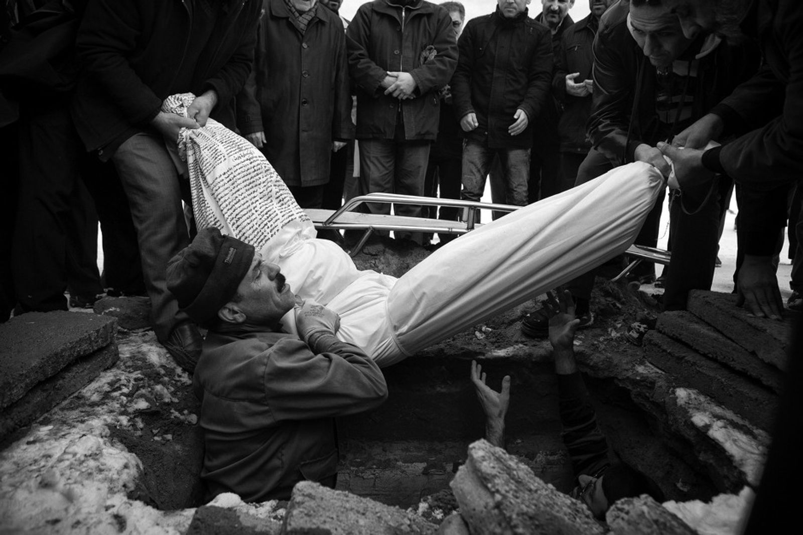© Jalal Shams Azaran - Father's body when is putting into the grave.