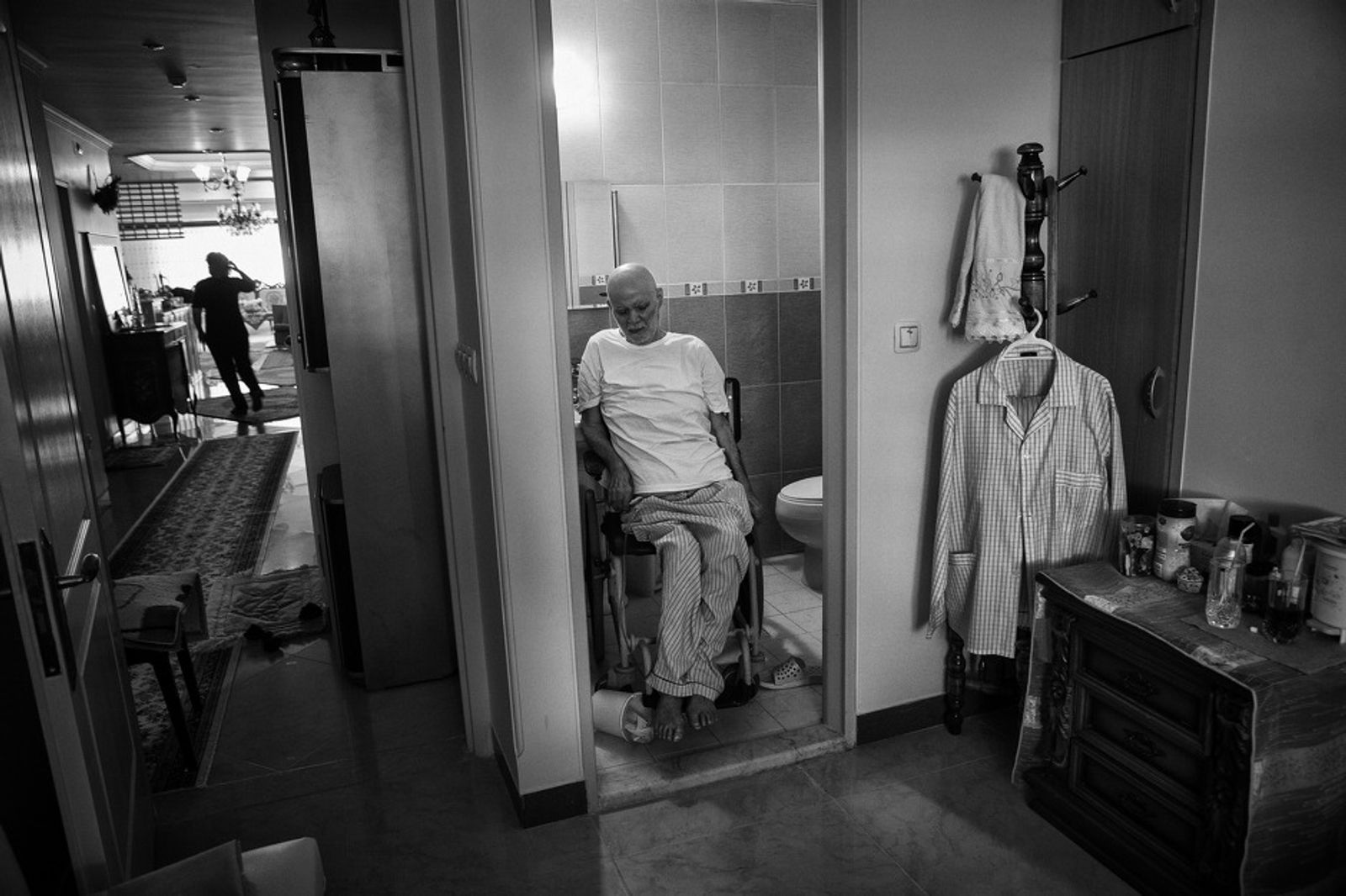© Jalal Shams Azaran - Father is in restroom waiting for his daughter, Delaaram, to help him.