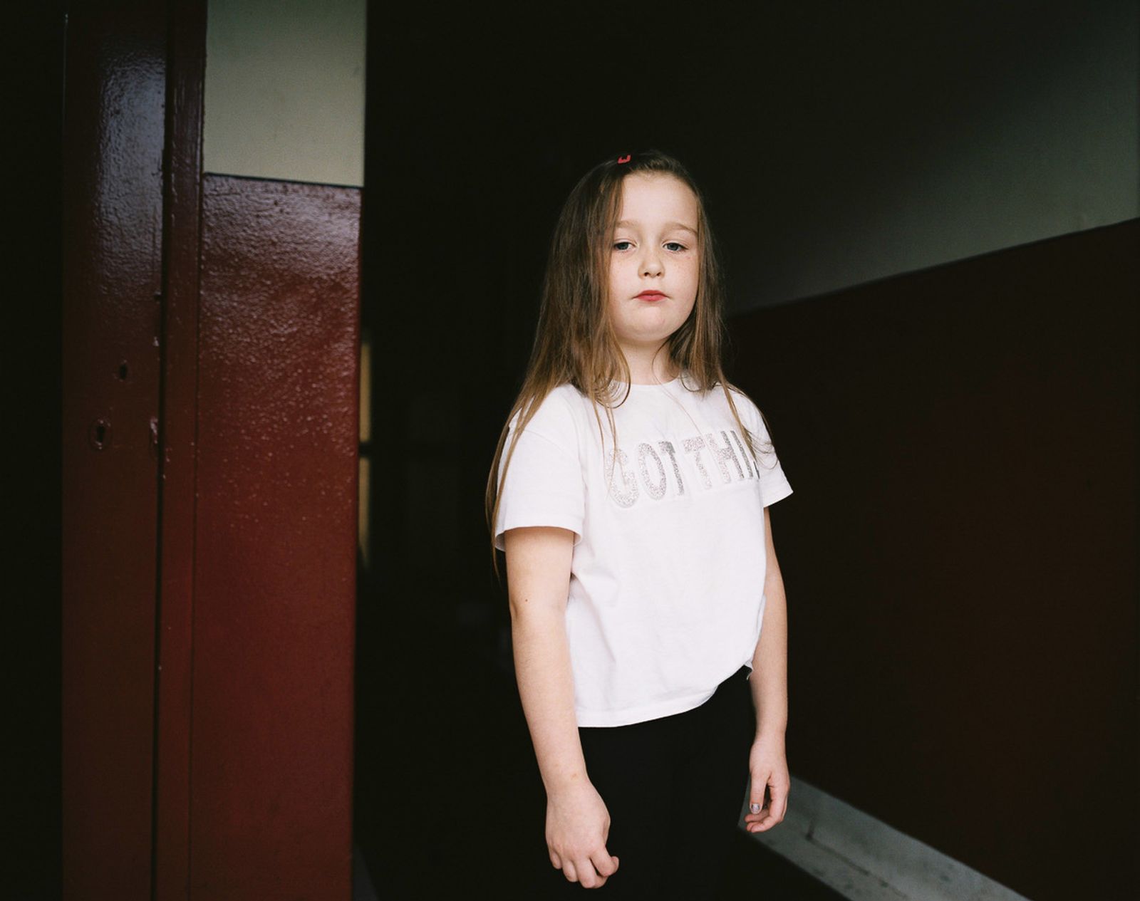 © Kirsty Mackay - Taylor age 7, stands in her grandmother's close in Easterhouse.