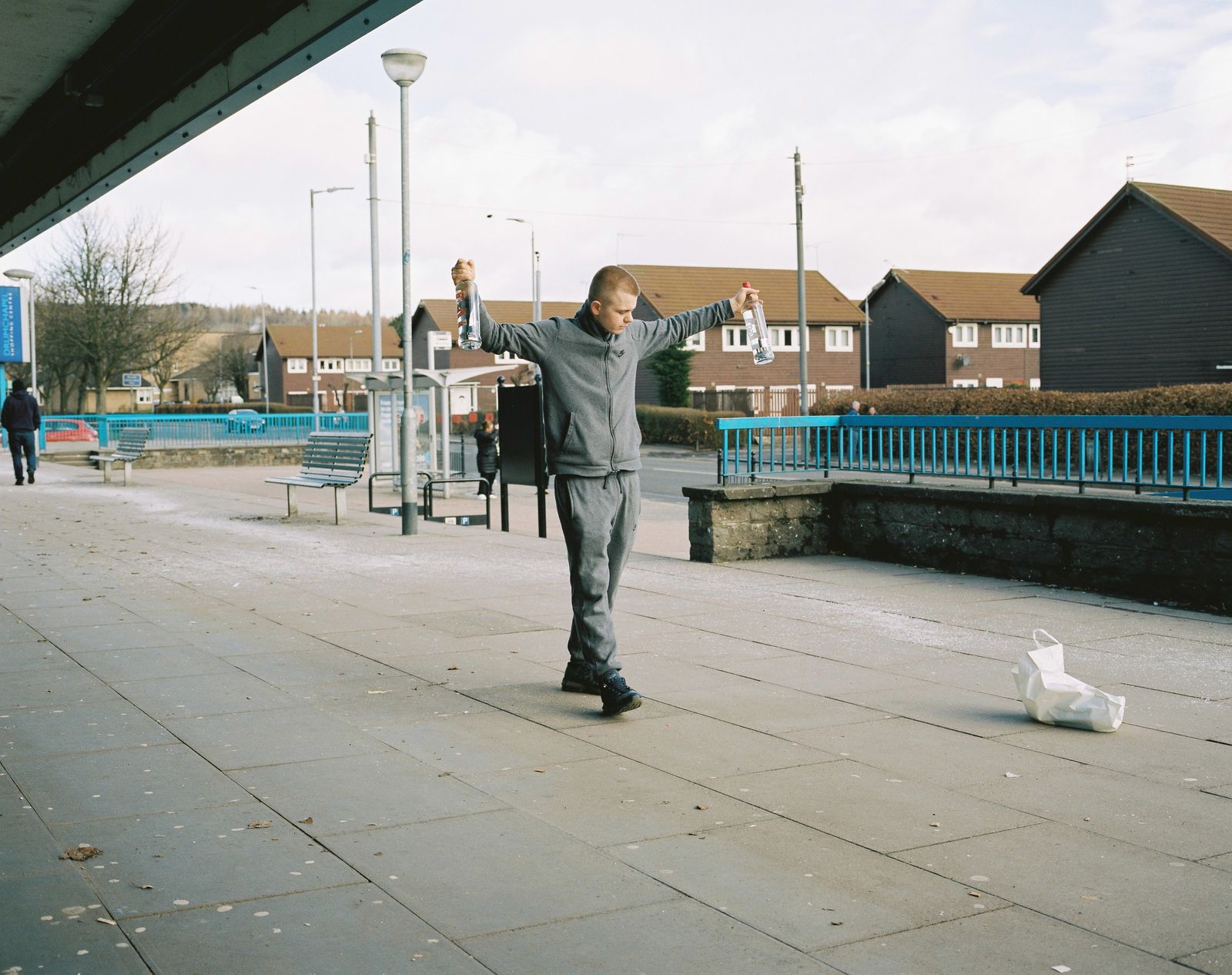 © Kirsty Mackay - A young man shows off his 'carry out' outside Drumchapel shopping centre.