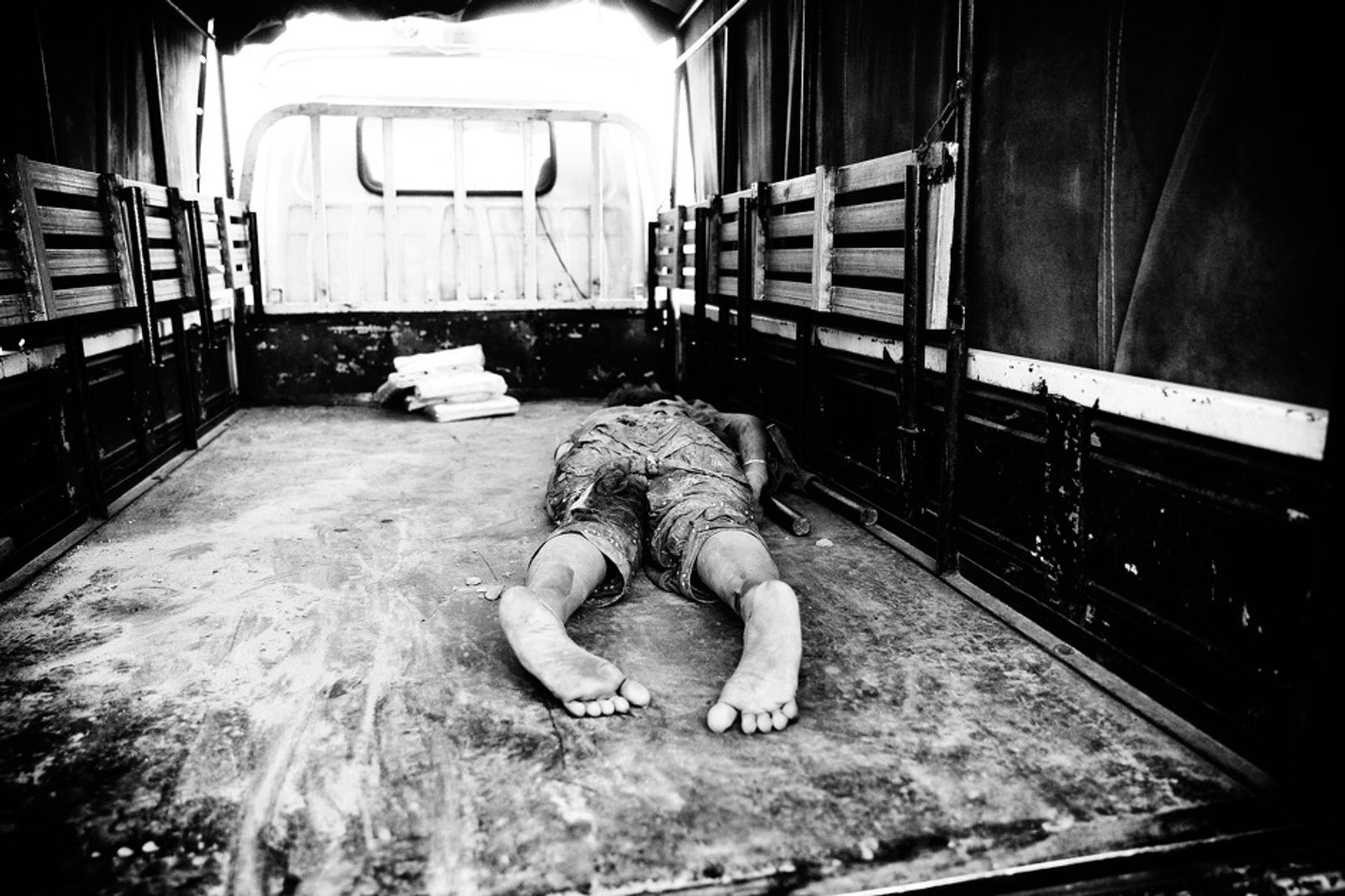 © Suvra Kanti Das - Dead body of a garments worker lay inside of the truck, Savar, near Dhaka, Bangladesh