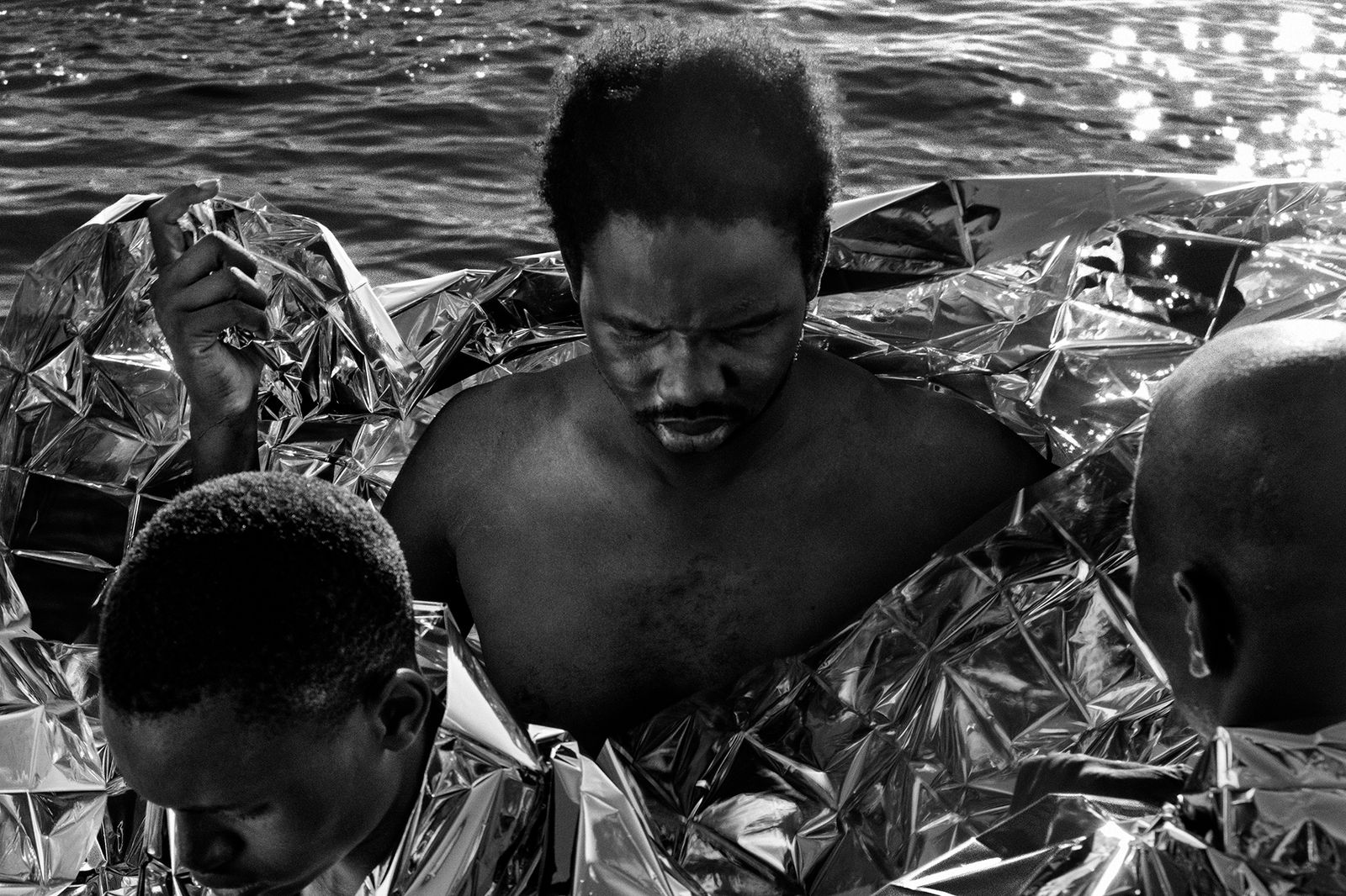 © Francesco Bellina - A man takes off his thermal blanket, after the rescue of Mediterranea.