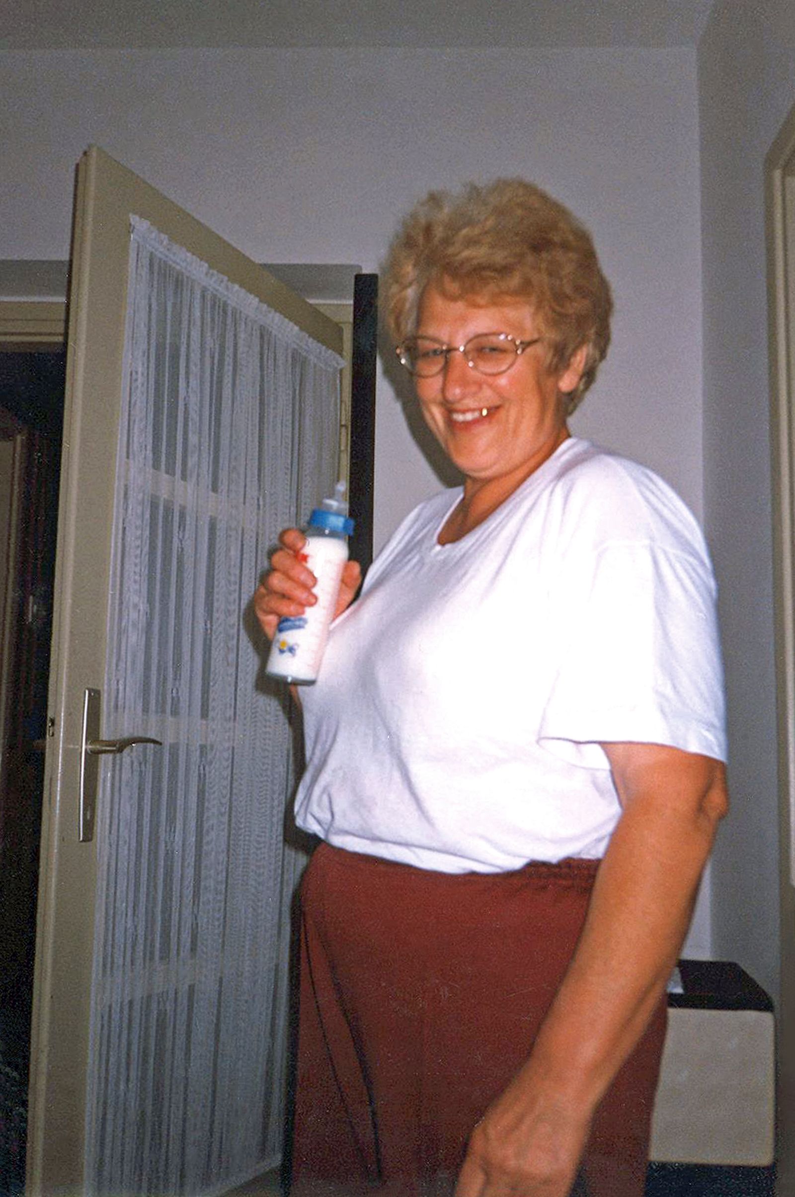© Lucija Rosc - My grandma holding baby bottle filled with warm milk.