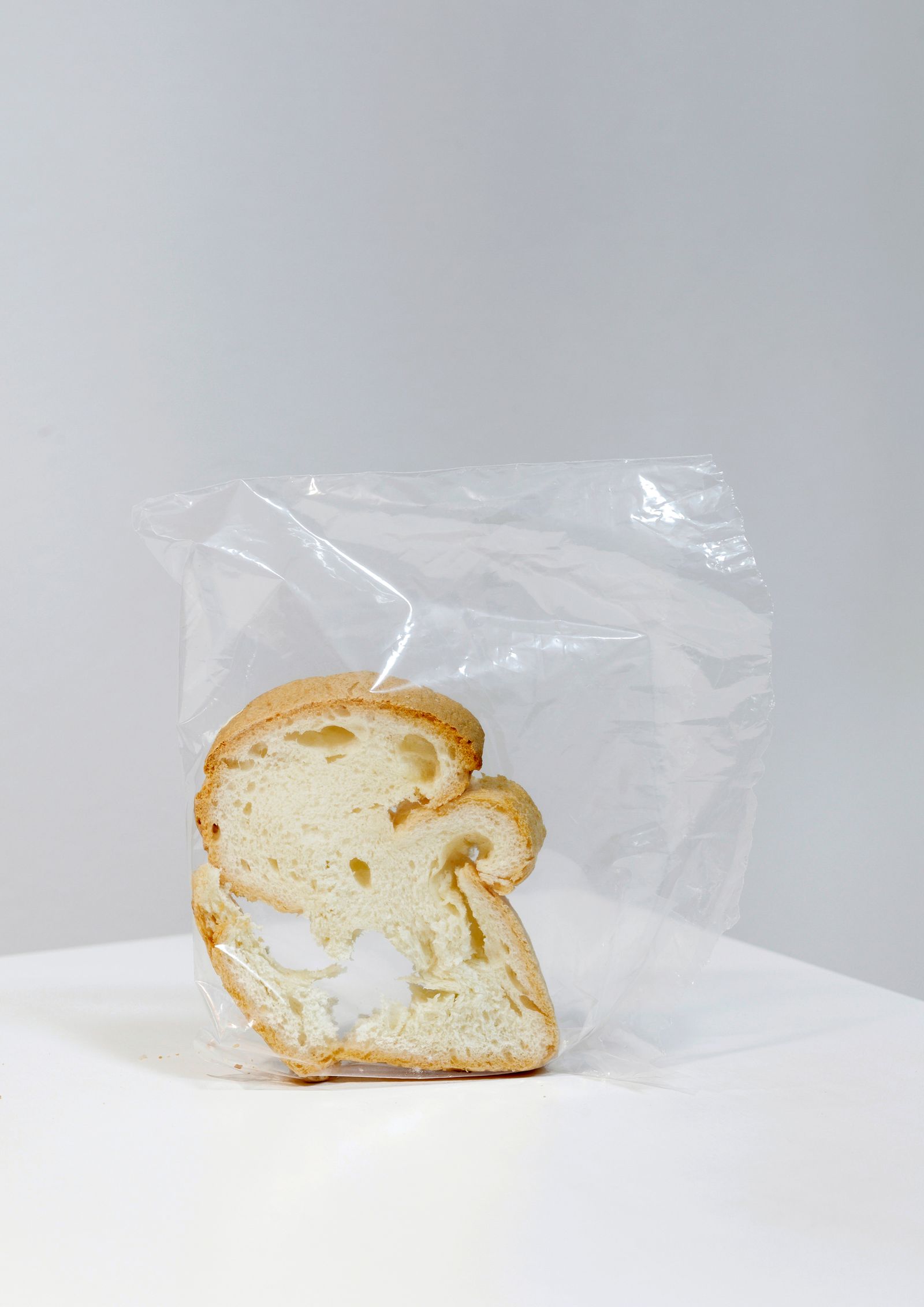 © Lucija Rosc - A piece of dry gluten-free bread that I found in our kitchen, standing upright in the plastic bag, exactly like this.