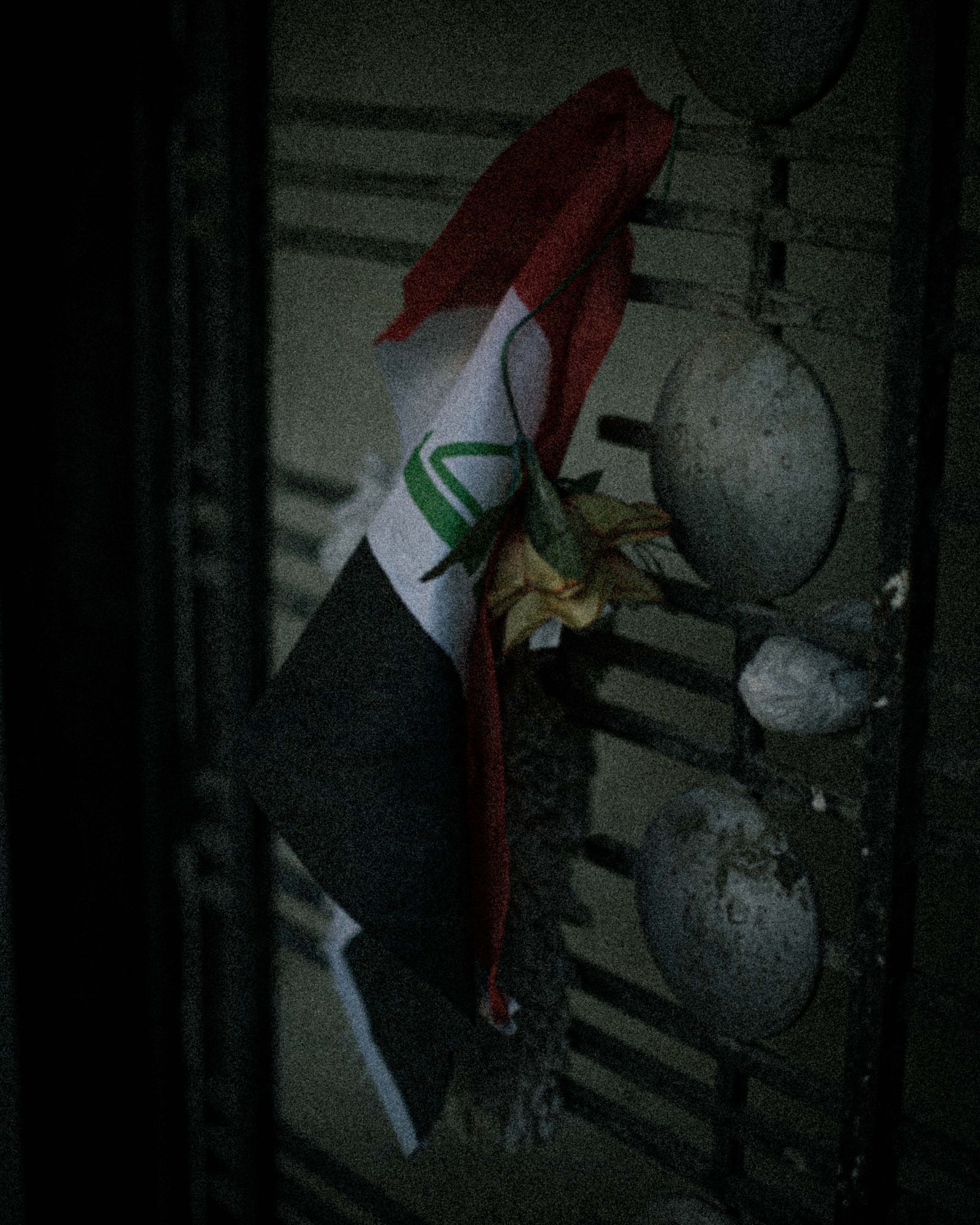 © Chloe Sharrock - A flag and a rose, symbol of a death, on the door of a grieved household in Baghdad.