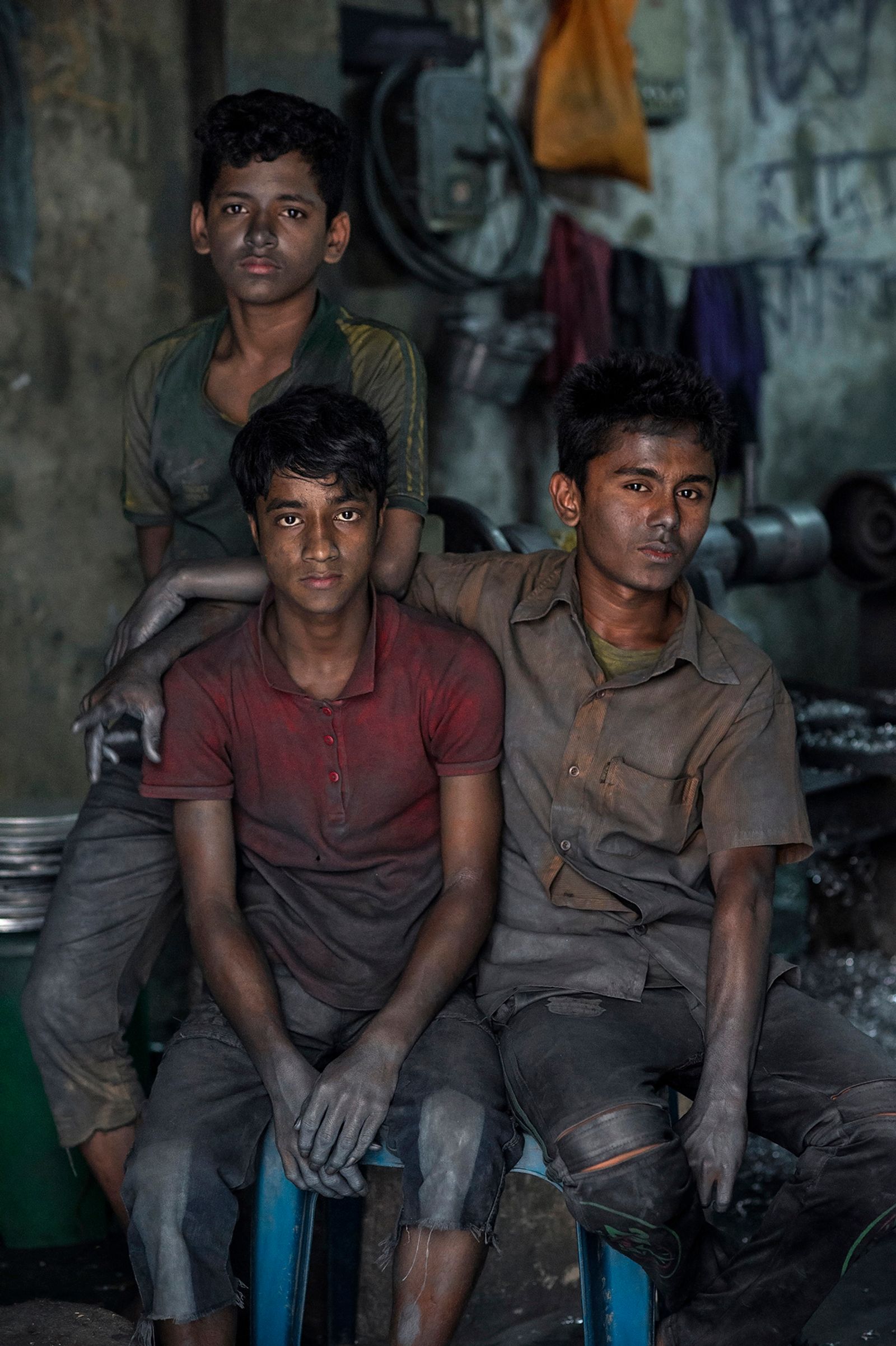 © Valerie Leonard - FRIENDSHIP. ￼Imran (13), Nizam (14) and Hossain (15), work in an aluminum pot factory. They make 1$ a day.