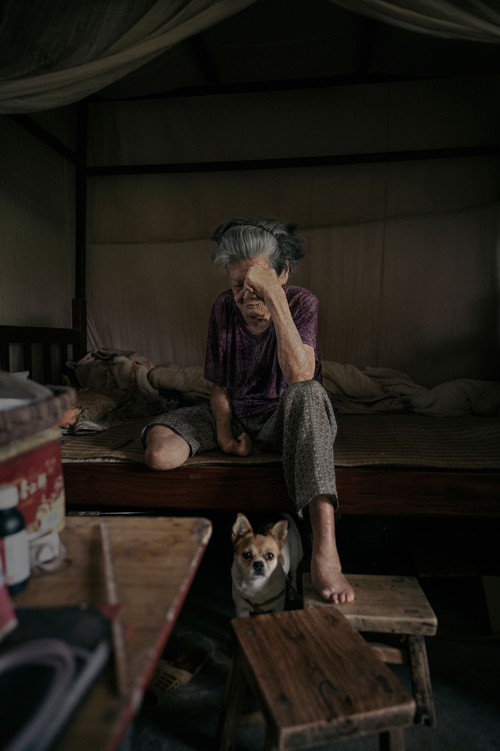© Jin TIAN - An old woman and her beloved dog A deaf-mute woman was abandoned in relying on each other