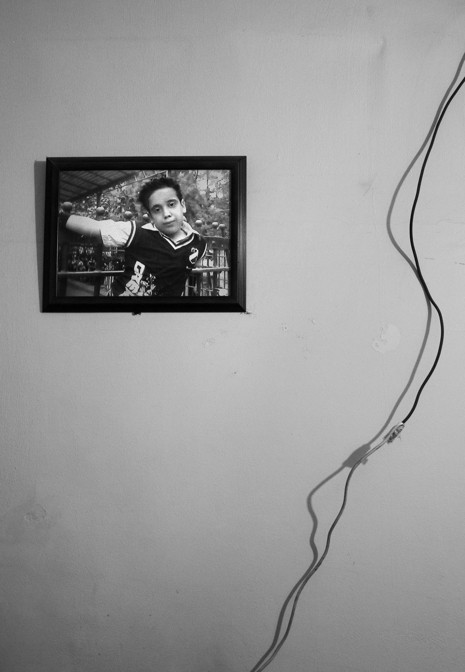 © Lamees Saleh Sharaf Eldin - A picture of Ahmed Jamal , Ten years old, hangs in front of his mother's bed.