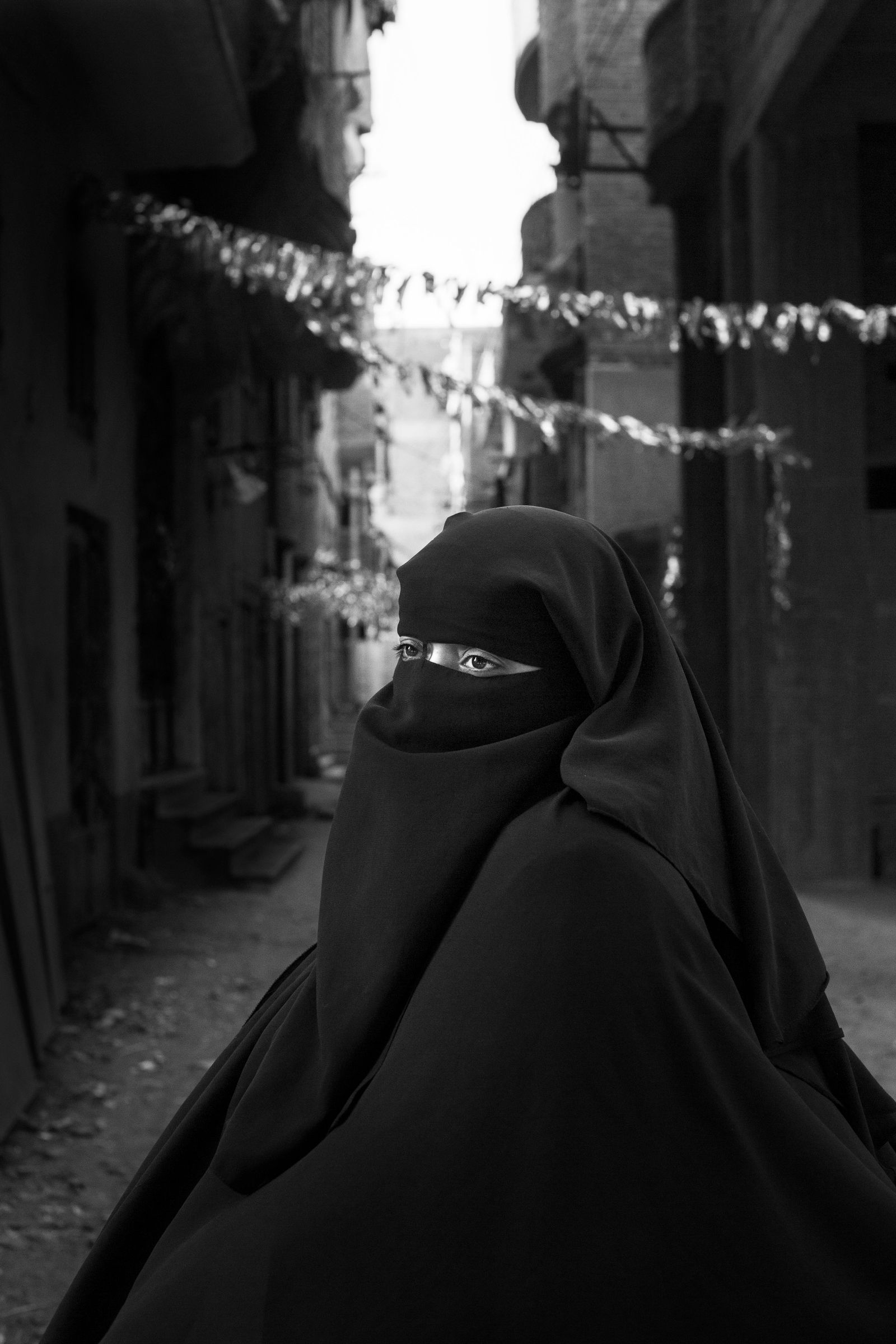 © Lamees Saleh Sharaf Eldin - Manal, Ruqayya's mother, stands in the street where Ruqaiya used to play with her friends.