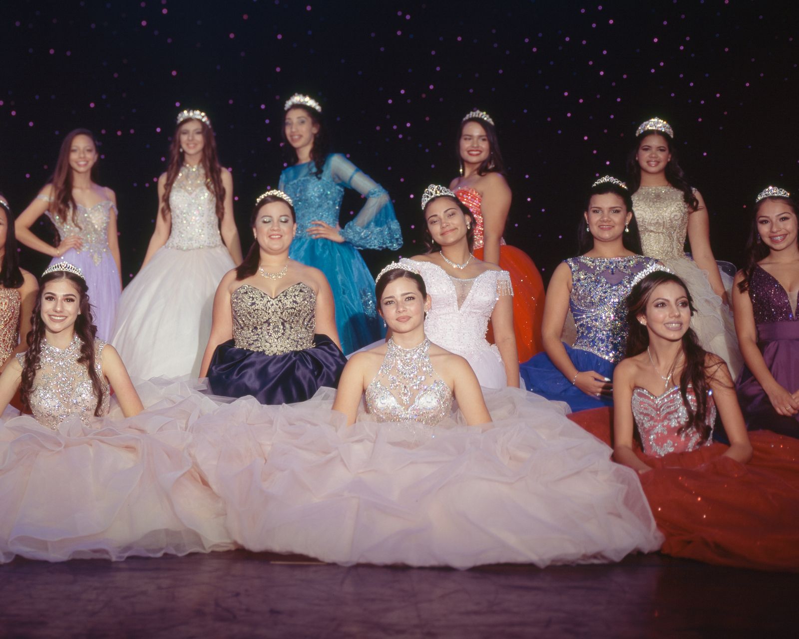 © Samantha Cabrera Friend - Quinceañeras grouped by untraditional dress color, smile for a final group portrait amid the performance