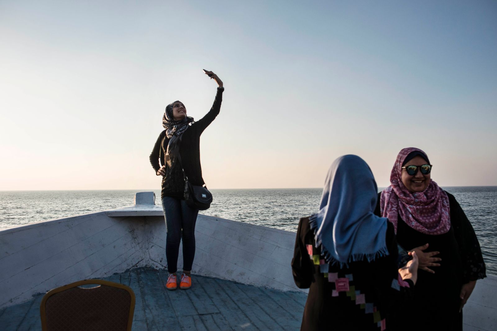 © Monique Jaques - Doaa takes a selfie at a cafe on the water in Gaza.