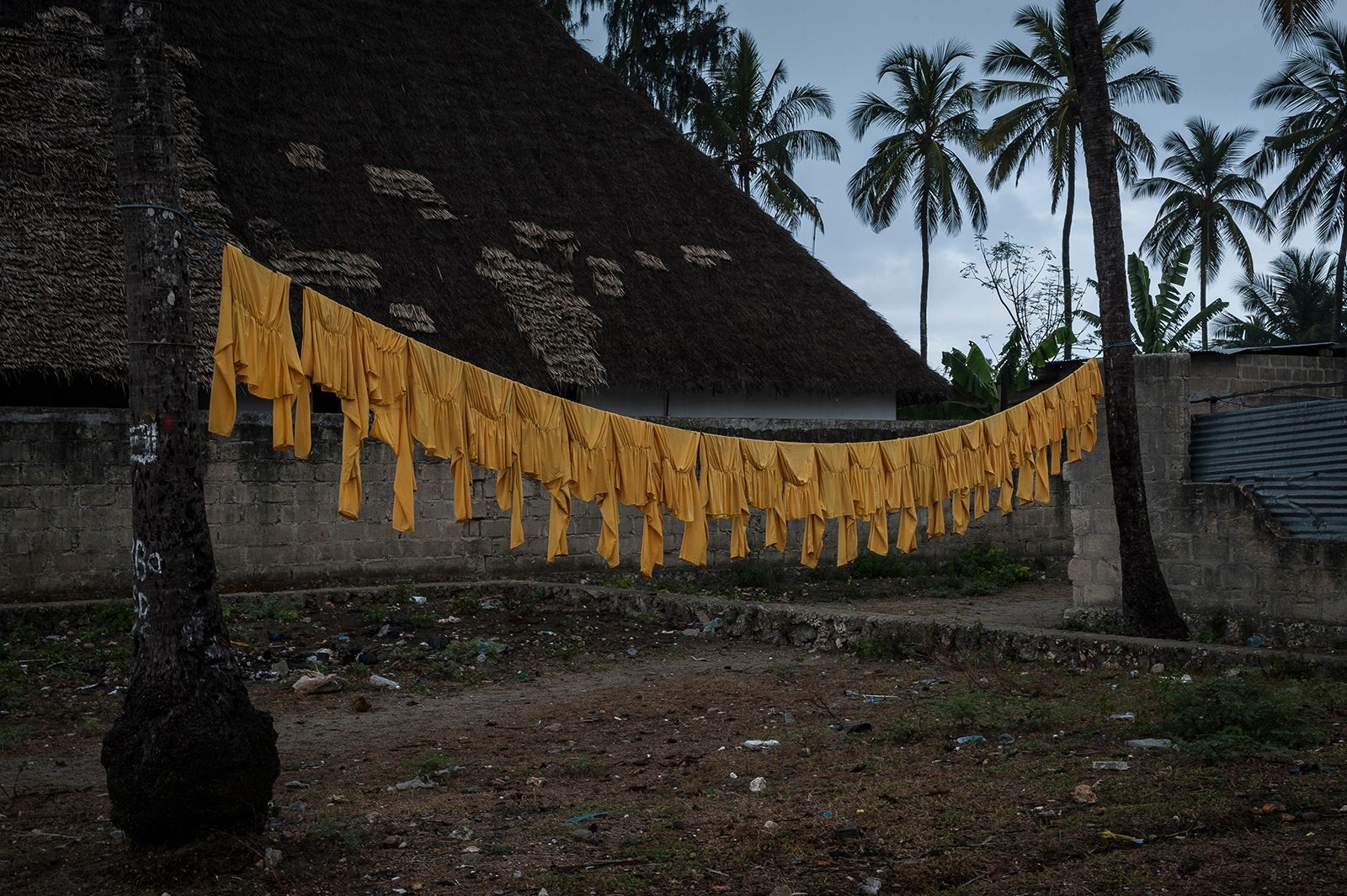 © Anna Boyiazis - Full-length swimsuit tops hang on a clothesline outside the home of Kazija’s mother in Nungwi, Zanzibar.