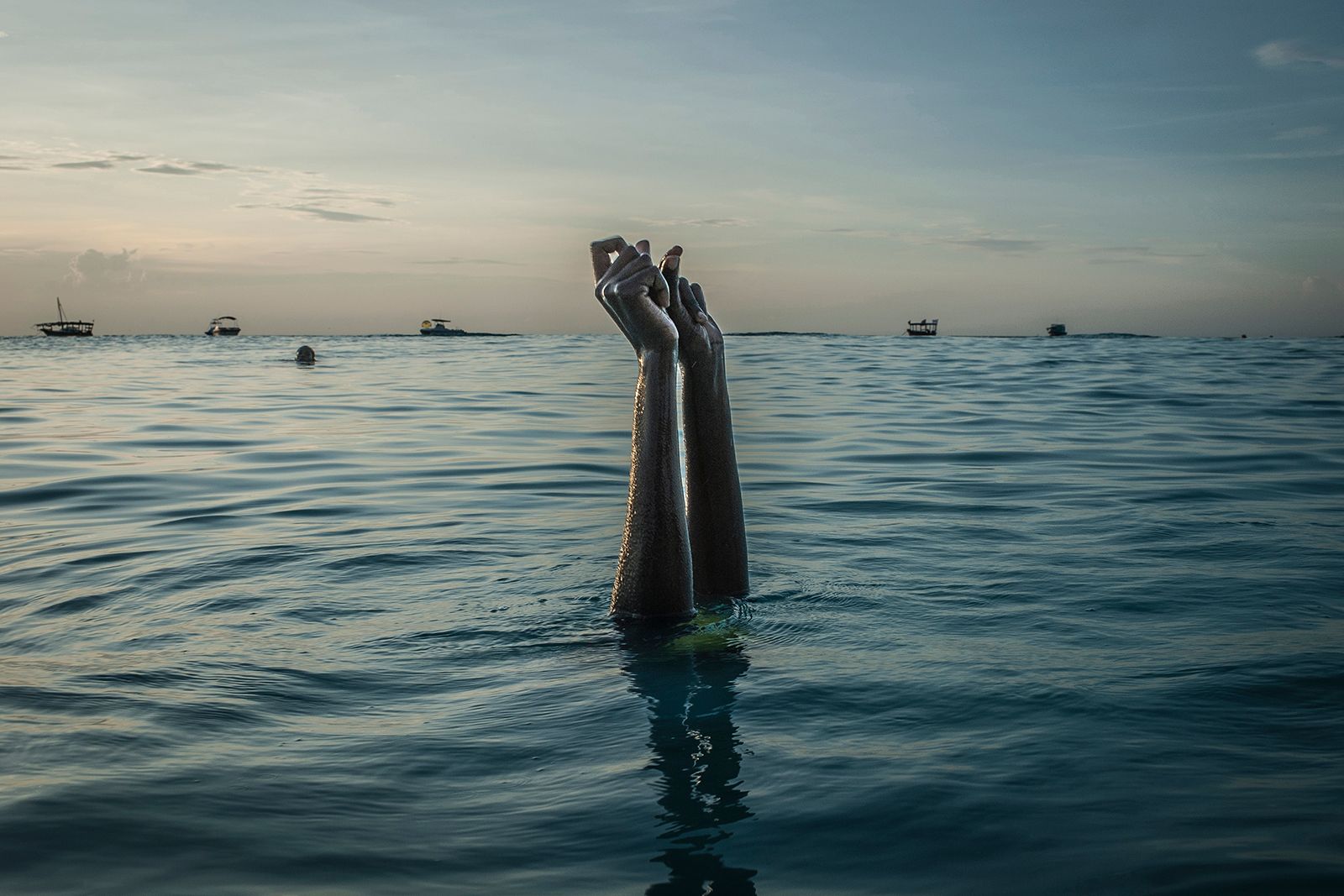 © Anna Boyiazis - Swim instructor Chema, 17, snaps her fingers as she disappears underwater in Nungwi, Zanzibar.