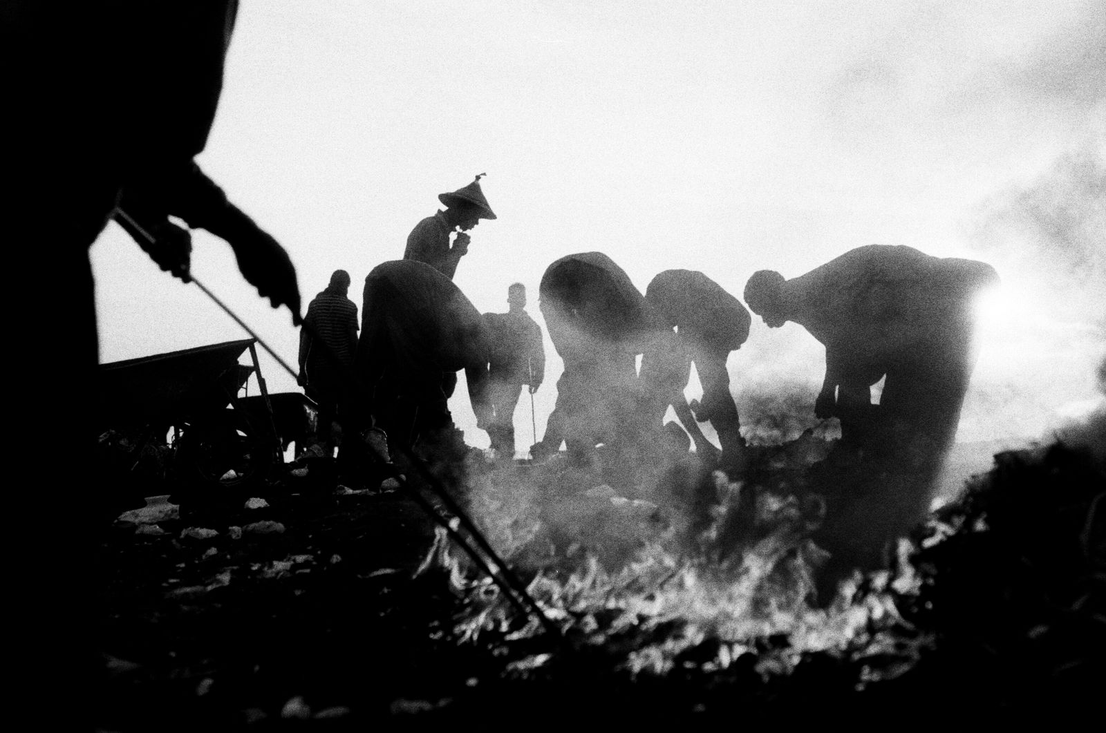 © carolina rapezzi - Accra. Agbogbloshie. A group of workers in the "Kilimanjaro" burning area burning wires and appliances.