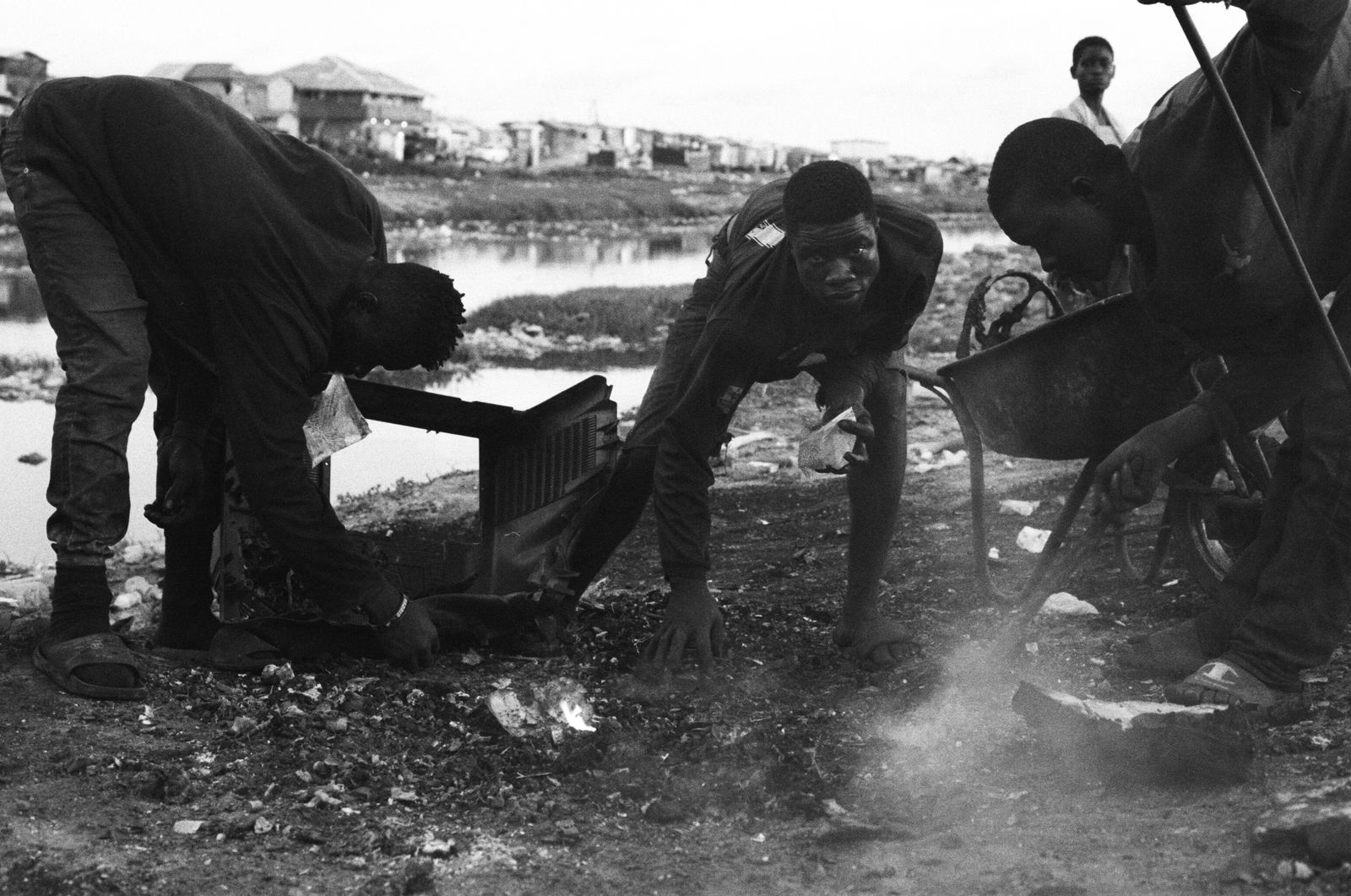© carolina rapezzi - Accra, Agbogbloshie. A group of workers in the "Kilimanjaro" area picking up metal scraps from the ground.