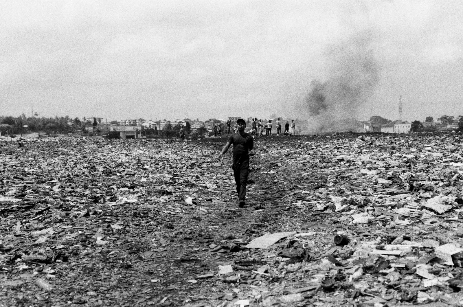 © carolina rapezzi - Accra, Agbogbloshie. A worker leaving from one of the burning areas of the filed.