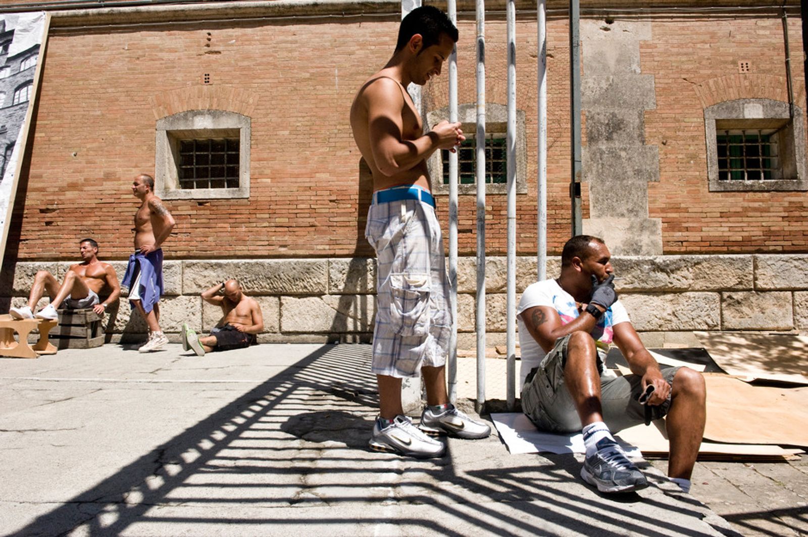 © Clara Vannucci - Volterra Maximum Security Prison, Italy. Compagnia della Fortezza. Prisoners chilling in the courtyard.