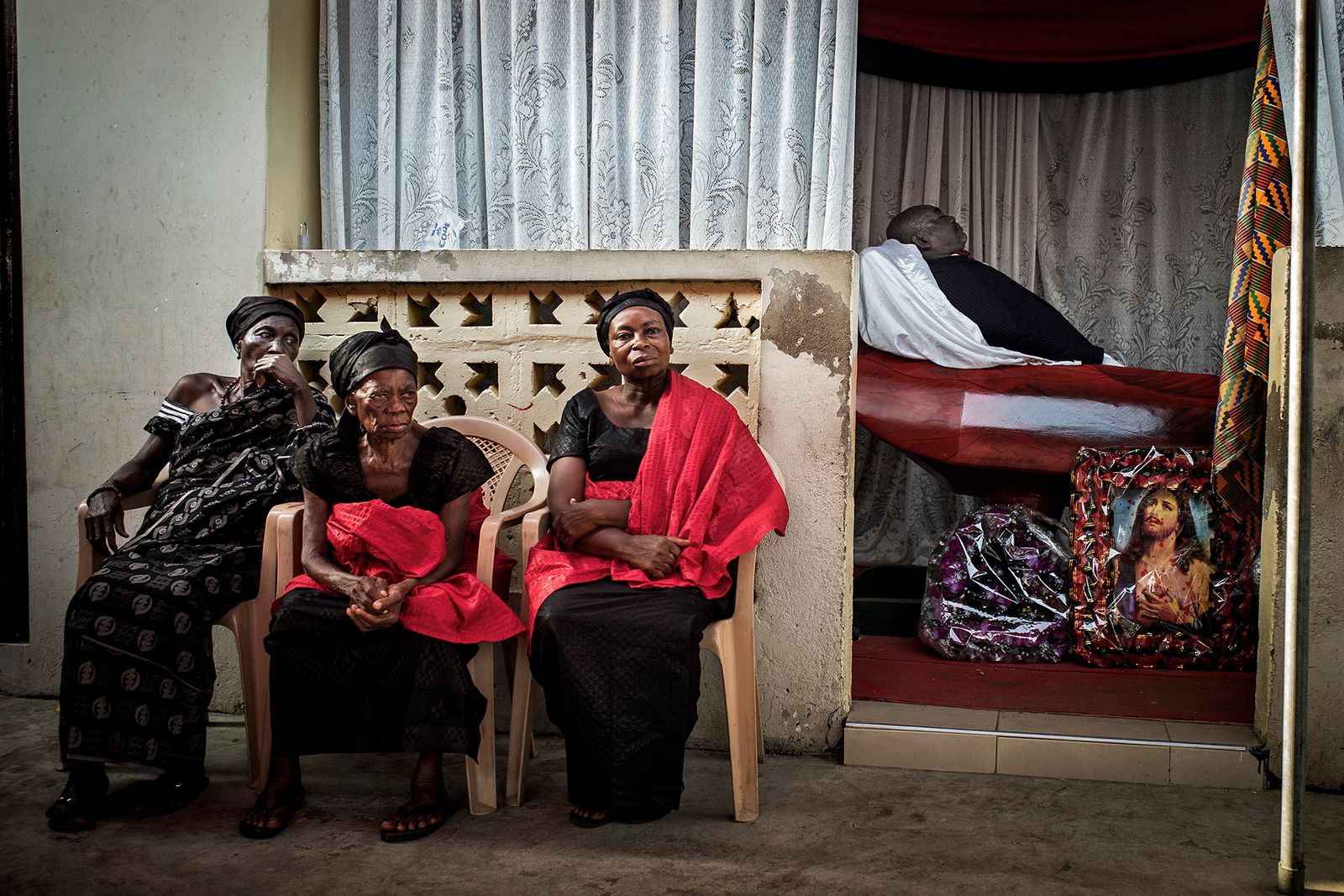 © Klaus Bo - GHANA - Nene Nomo is laying in state while his widow and family members sits outside.