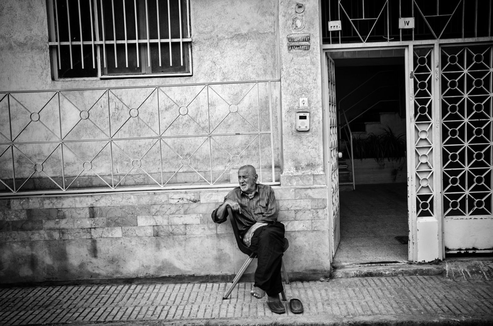 © Khashayar Sharifaee - Grandfather is sitting out of house and enjoying the fresh air.