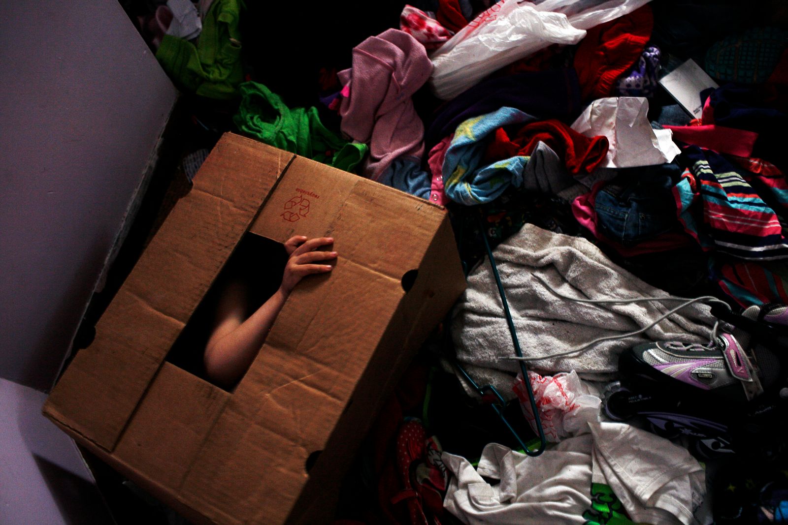 © Uno  Yi - David hides in a empty box during a game of hide-and-seek.