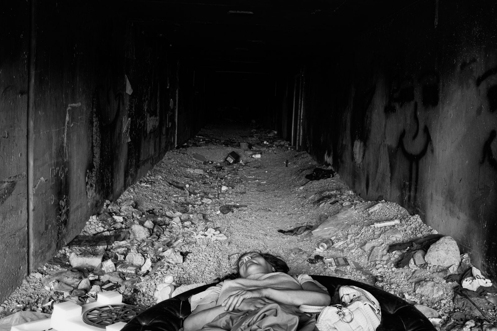 © Richard Sharum - A woman sleeps on an Ottoman at the entrance to one of the many tunnels leading under the Strip.