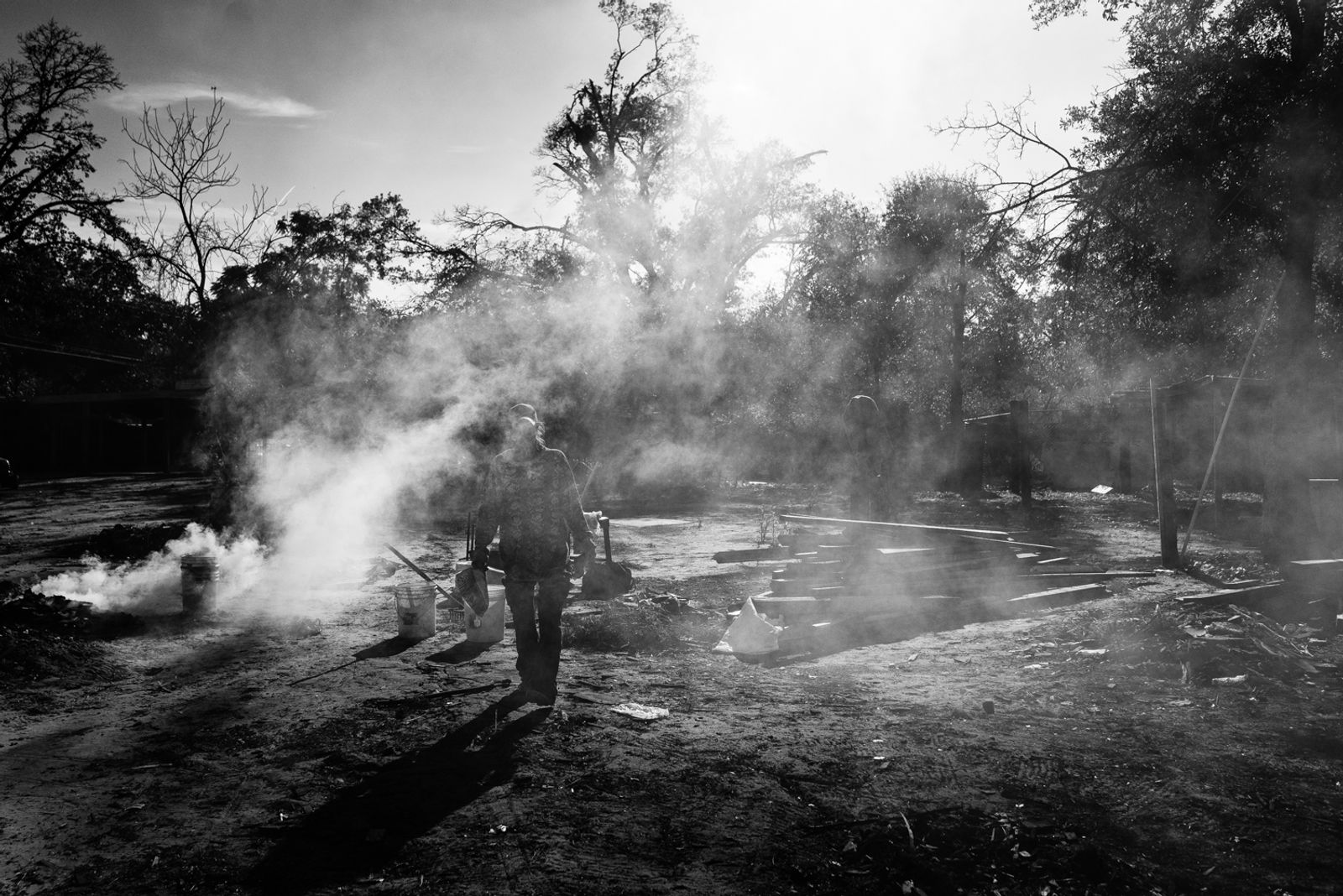 © Richard Sharum - A man burns a horse carcass that was dumped in the community overnight. 2019.