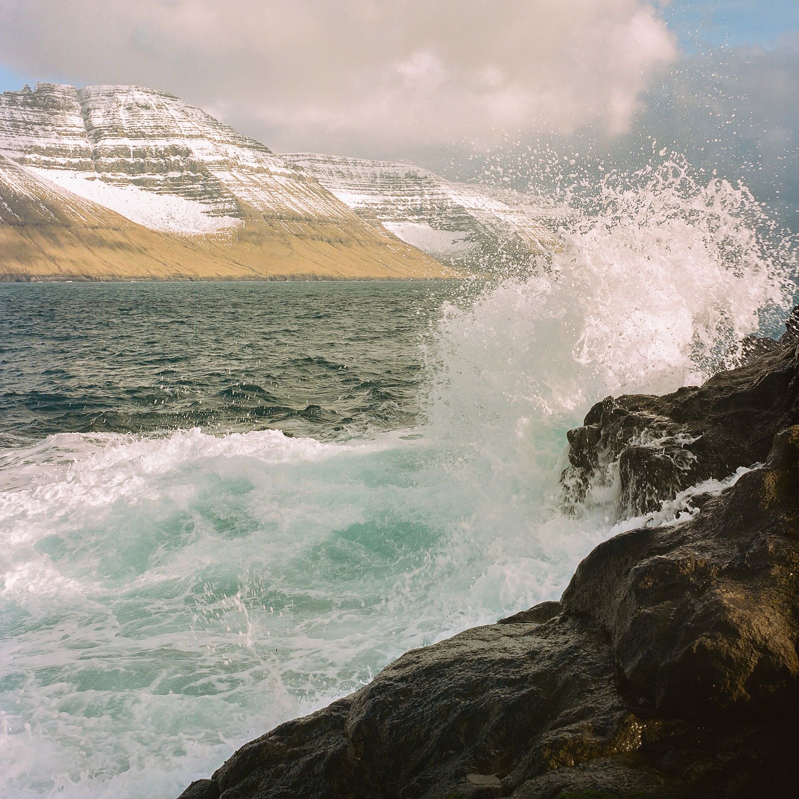 © Silvia Varela - A wave crashes on the rocks at the village of Mikladur, on the Faroese island of Kalsoy.