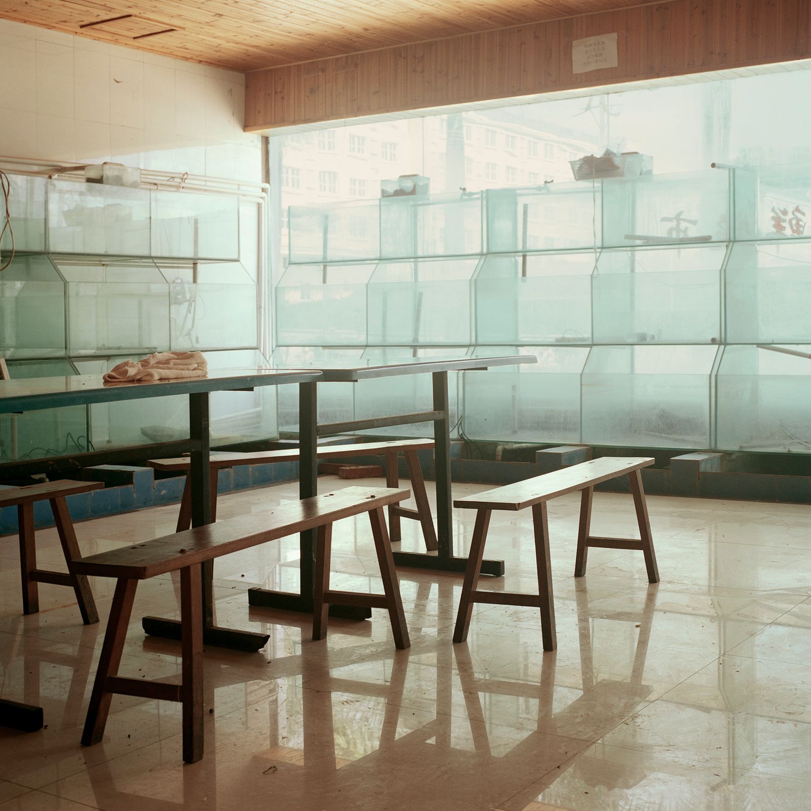 © Huiying Ore - Empty seafood tanks and furniture in a restauant at Boten city gather dust after a long period of disuse.