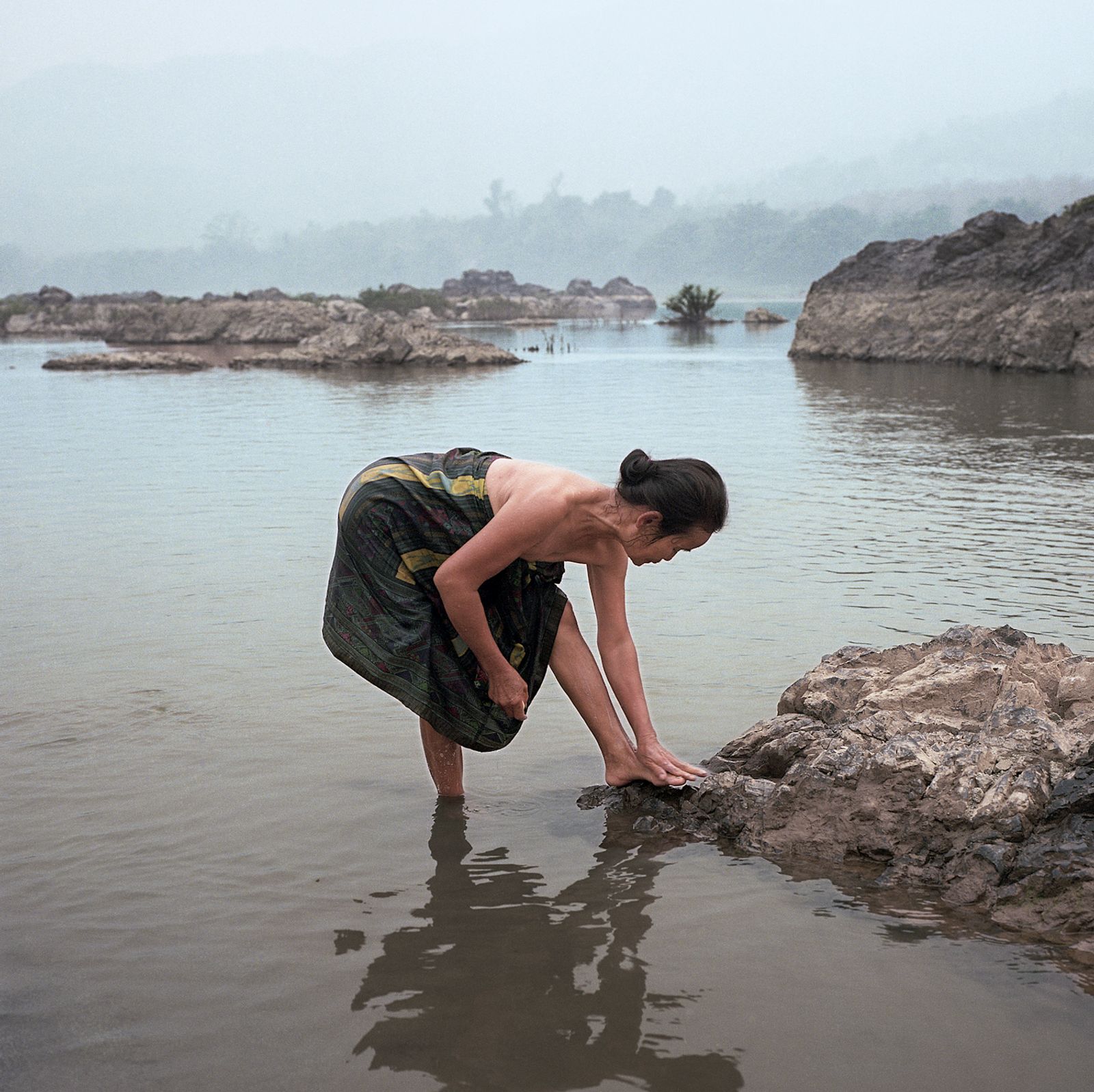 © Huiying Ore - A villager living along the Mekong River takes her daily evening bath in the river.