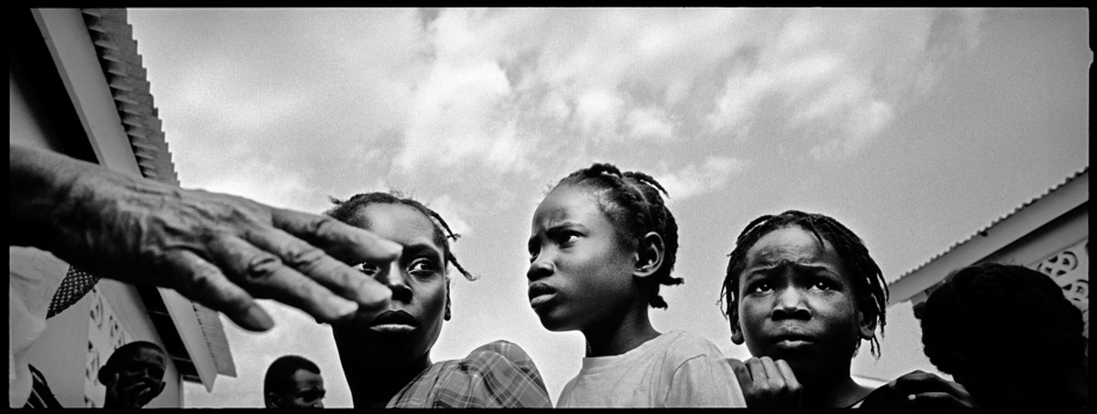 © Benjamin Rusnak - A trio of girls anxiously waits in line for food at a relief agency distribution near Port-au-Prince, Haiti.