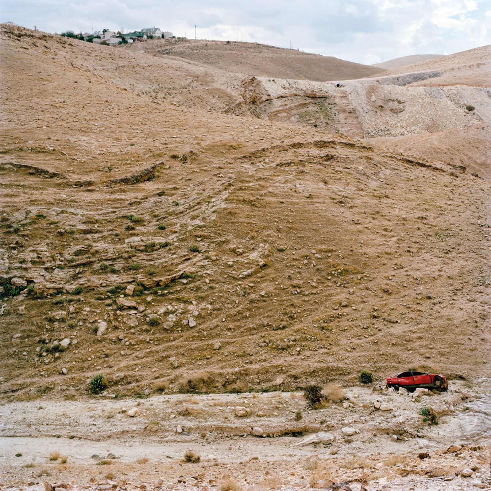 © Federico Busonero - Wrecked car in Wadi Qelt, Israeli settlement above, Palestine.