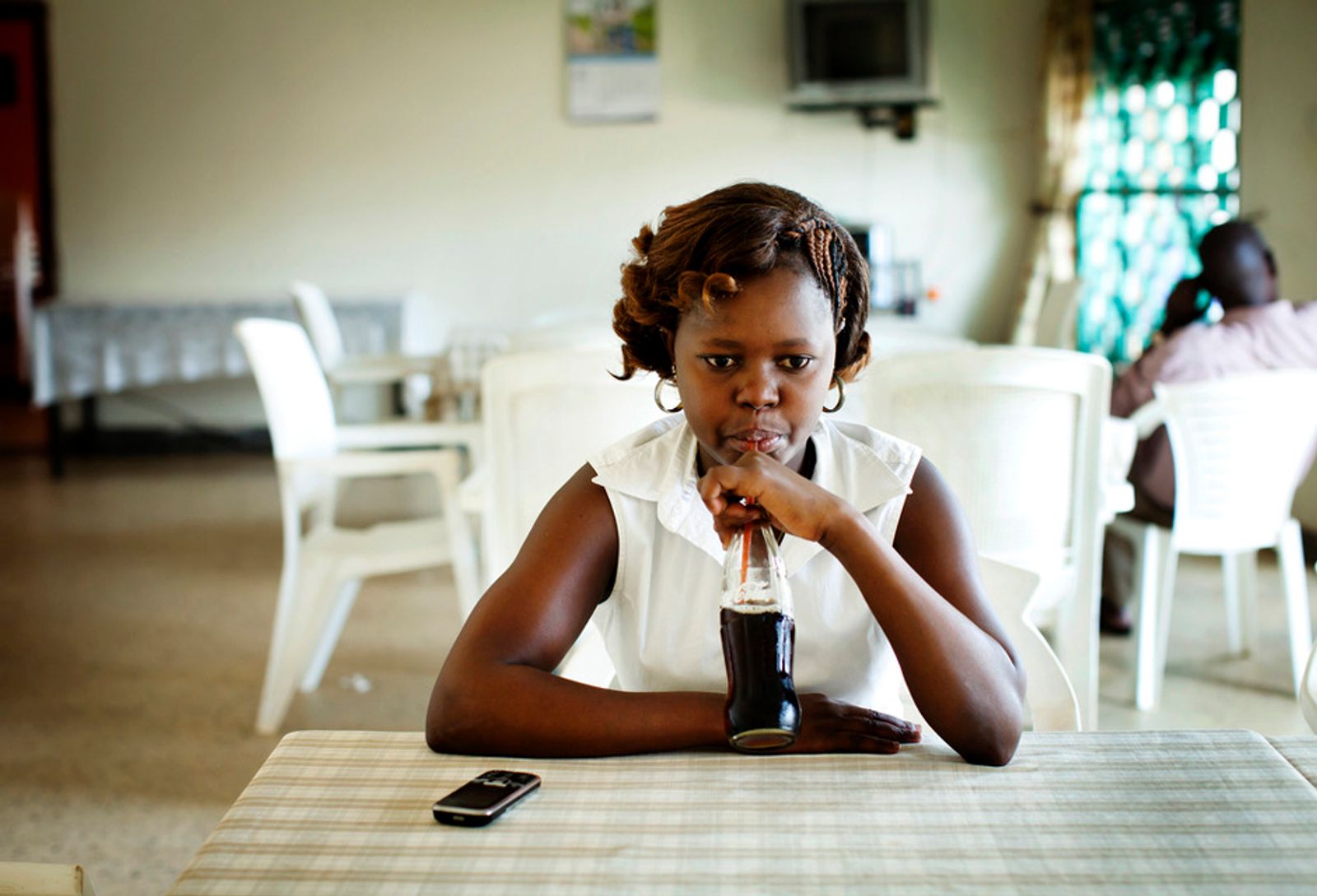 © Anne Ackermann - Lady Sharia, a young musician from Gulu enjoys her soda in a local restaurant.
