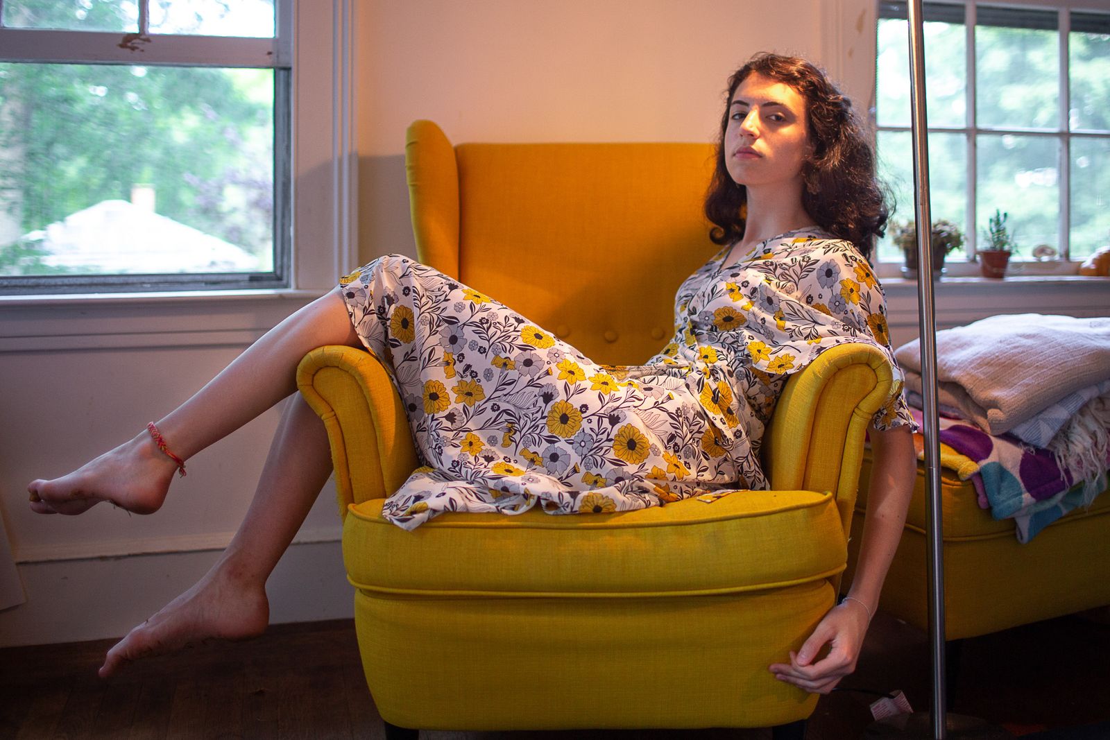 © Lindsay Morris - Hannah, in a similar style dress to one that she favored at camp, sits for a portrait in her bedroom (2020).