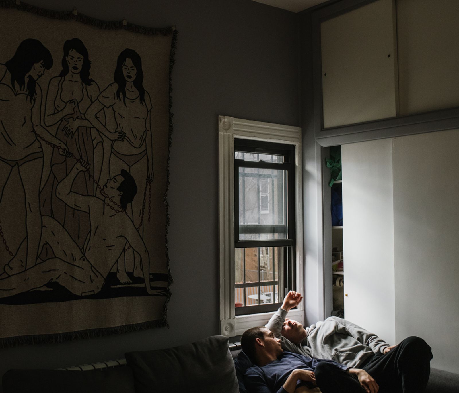 © Gili Benita - Sam (24 (R), and Eyal Chowers (25) (L), lying on their couch inside their Ridgewood apartment in NYC, April 5th, 2020.