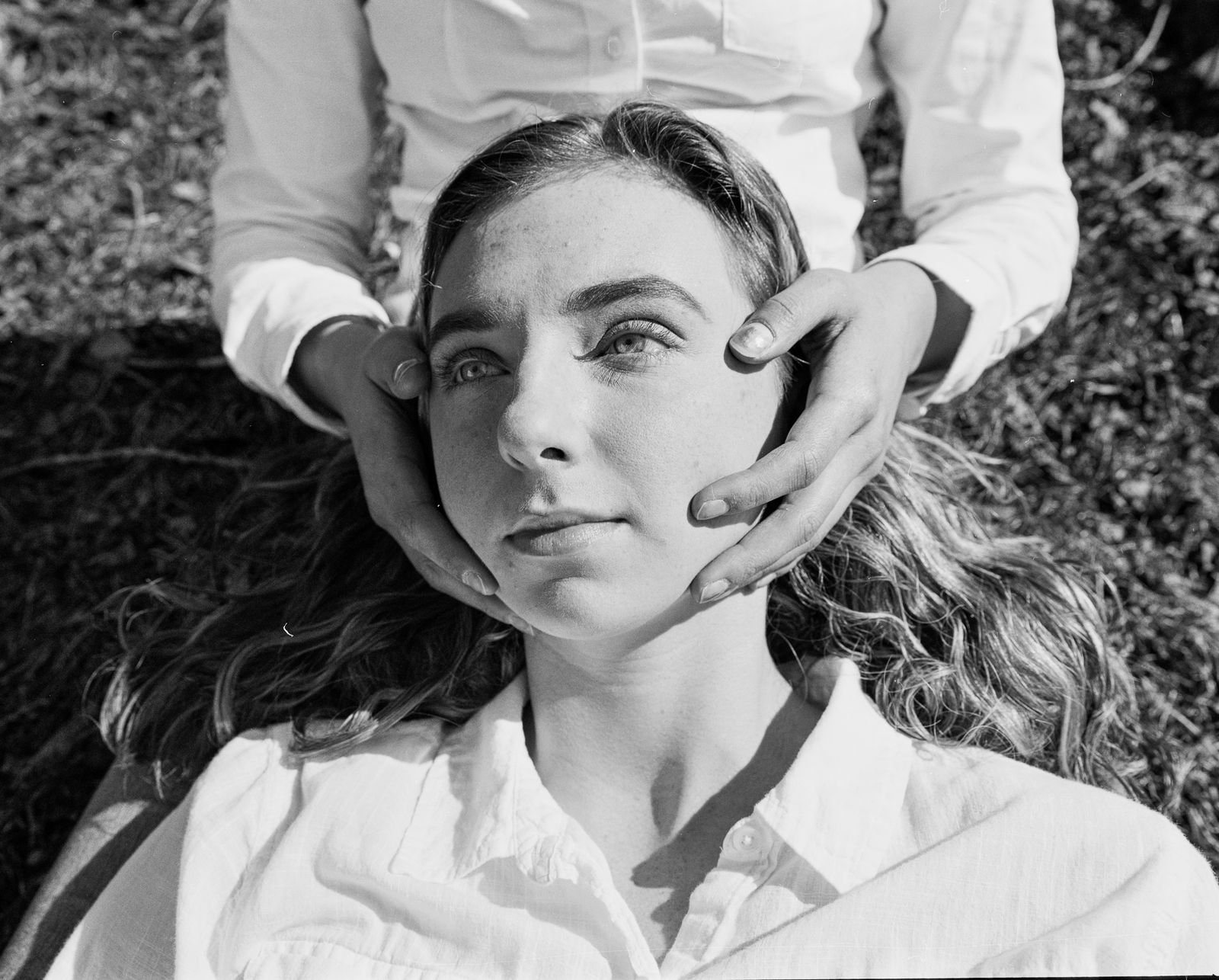 © Jillian Freyer - Lily holds Quinn's face while they recline on the winter lawn