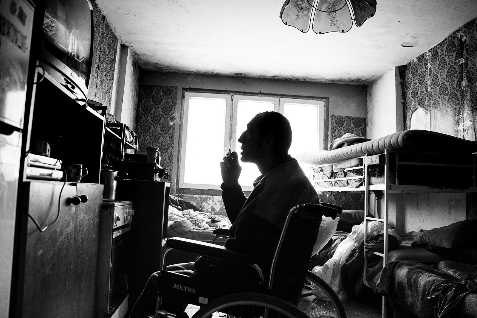 © Jana Plavec - Kája watching television in his shared apartment with another Roma family.