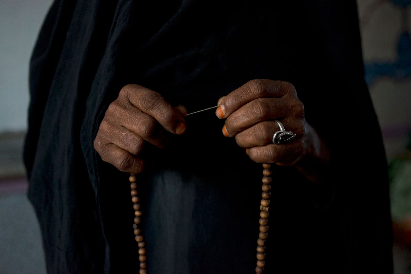© Alex Potter - A Yemeni woman displaced from her home in Sa'ada to a school in Sana'a holds her beads while praying.