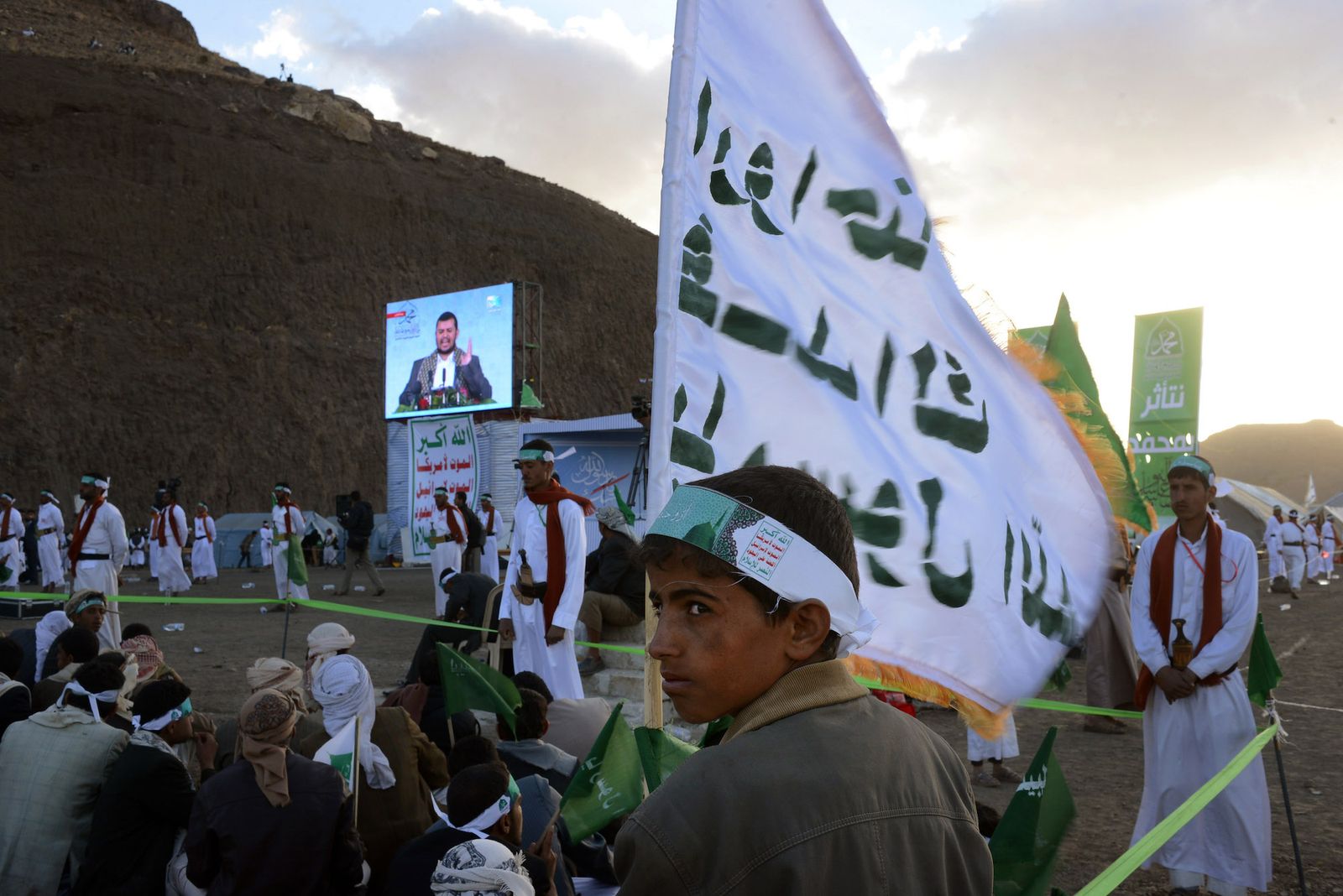 © Alex Potter - A young boy supporting the Houthis holds a flag at one of their rallies.