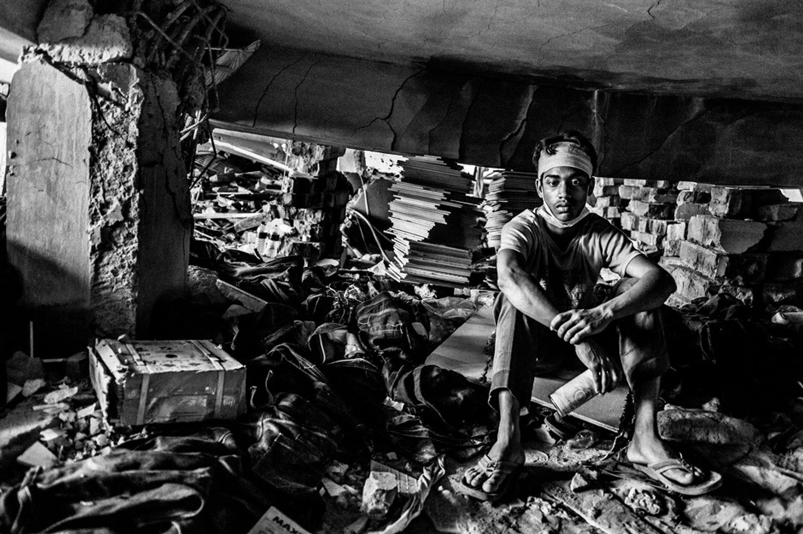 © Rahul Talukder - A tired rescue worker is taking rest during operations in the collapsed building.