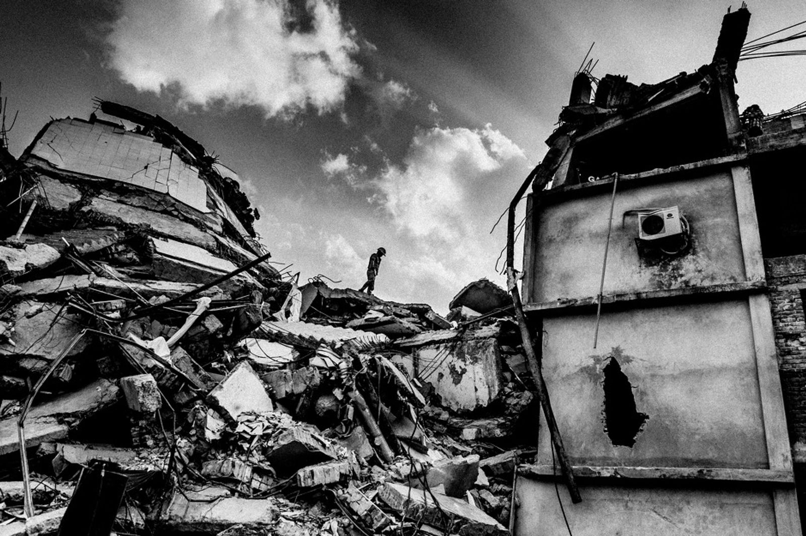 © Rahul Talukder - A rescue worker inspects the site before a rescue operation with heavy machinery begins.